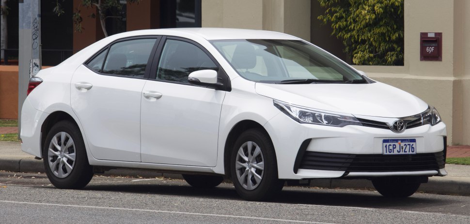 White sedan front and side view parked on street