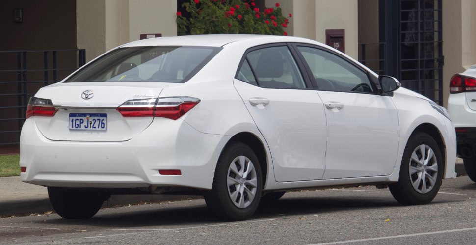 White compact sedan rear side with distinctive tail lights and wheel design