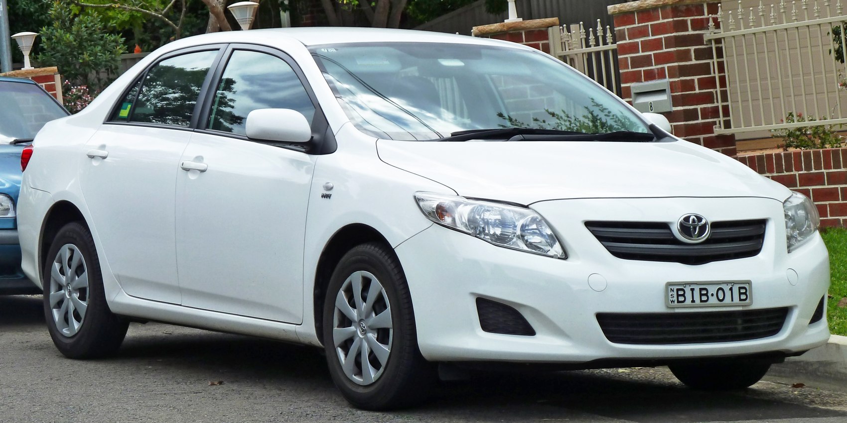 Compact white 4-door sedan with alloy wheels and clear headlights