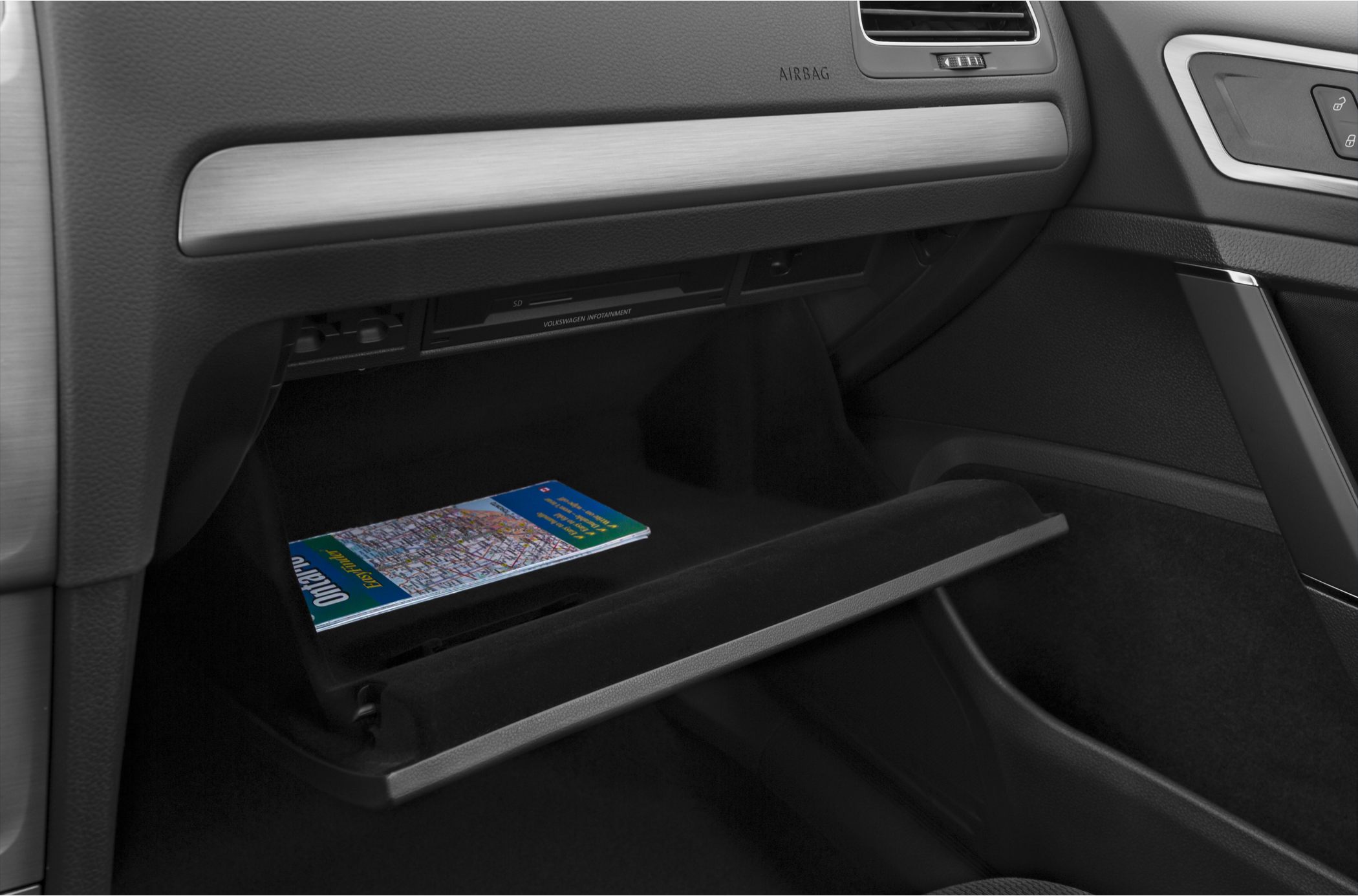 Open glovebox with map and infotainment slot in car interior