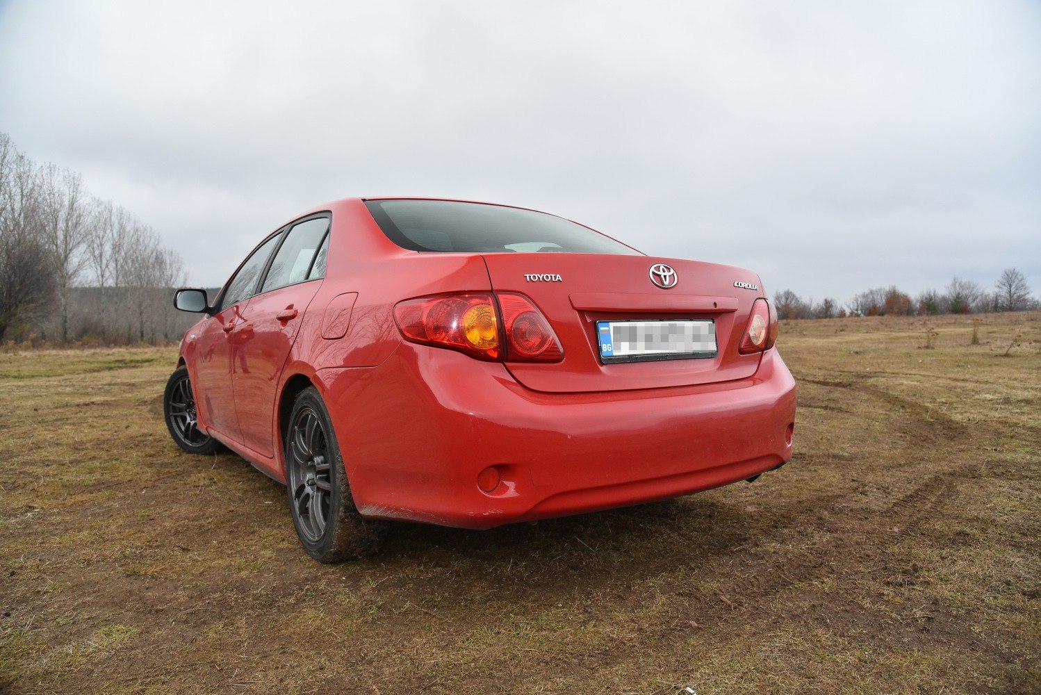 Red sedan rear view with distinct taillights and wheel design