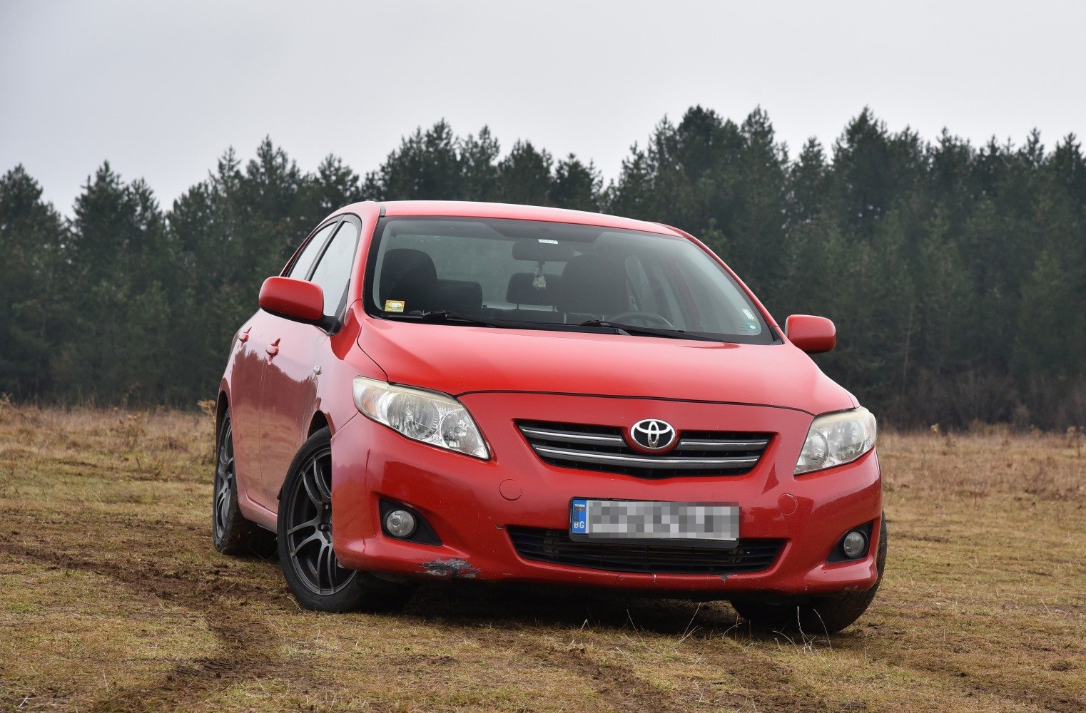 Front view of red sedan with black sporty wheels and fog lights