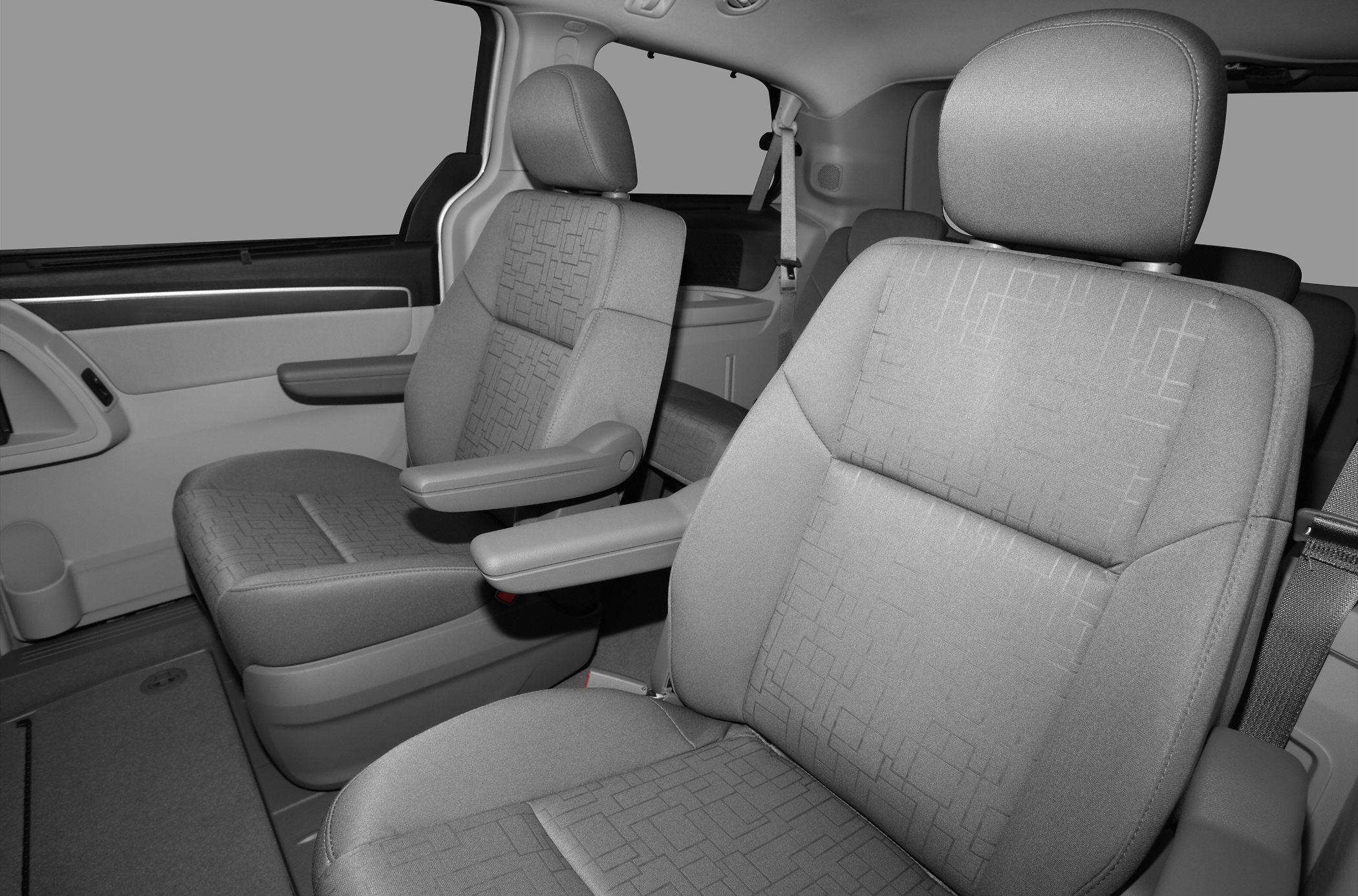 Cloth upholstered front seats with armrests and safety belts in vehicle interior
