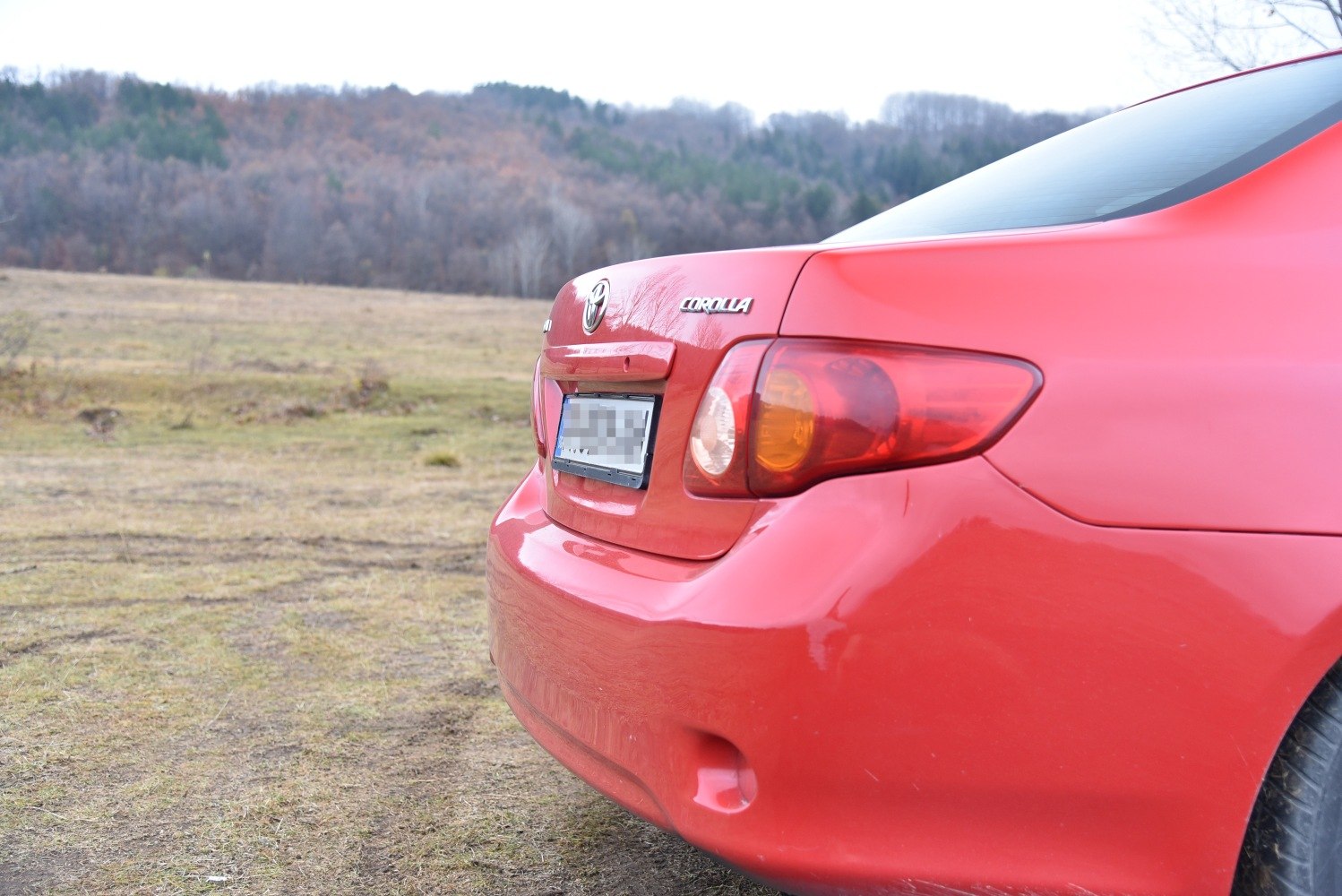 Rear side with tail light and bumper of a red vehicle
