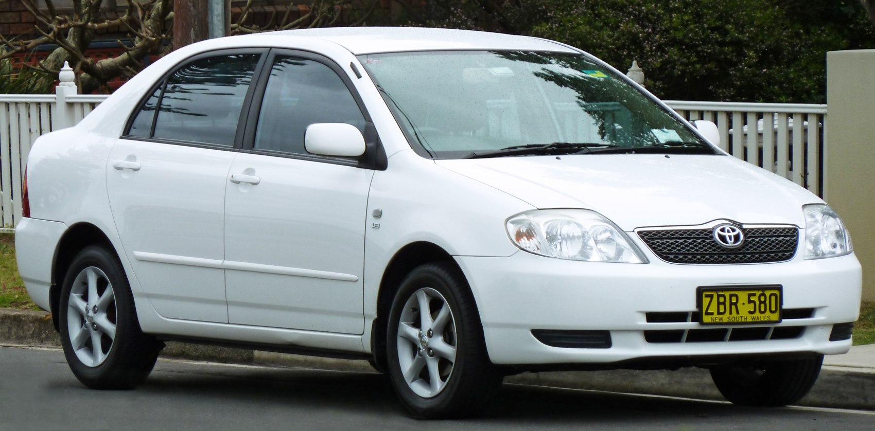 White sedan with front and side visible, alloy wheels and headlights