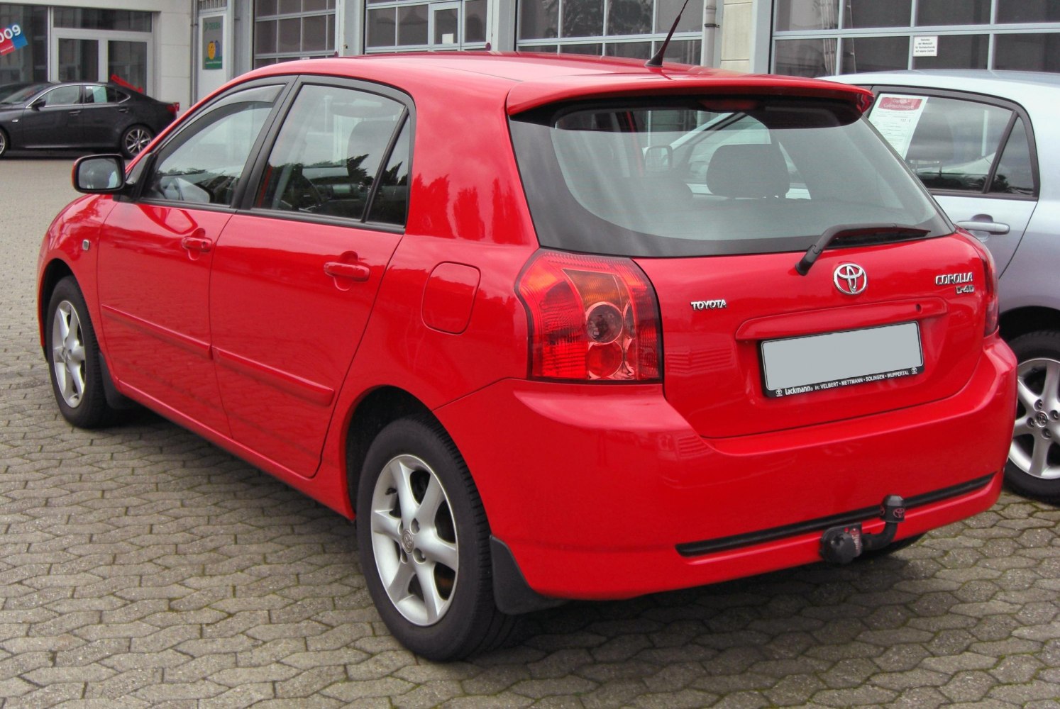 Red hatchback rear view with taillights and tow hitch