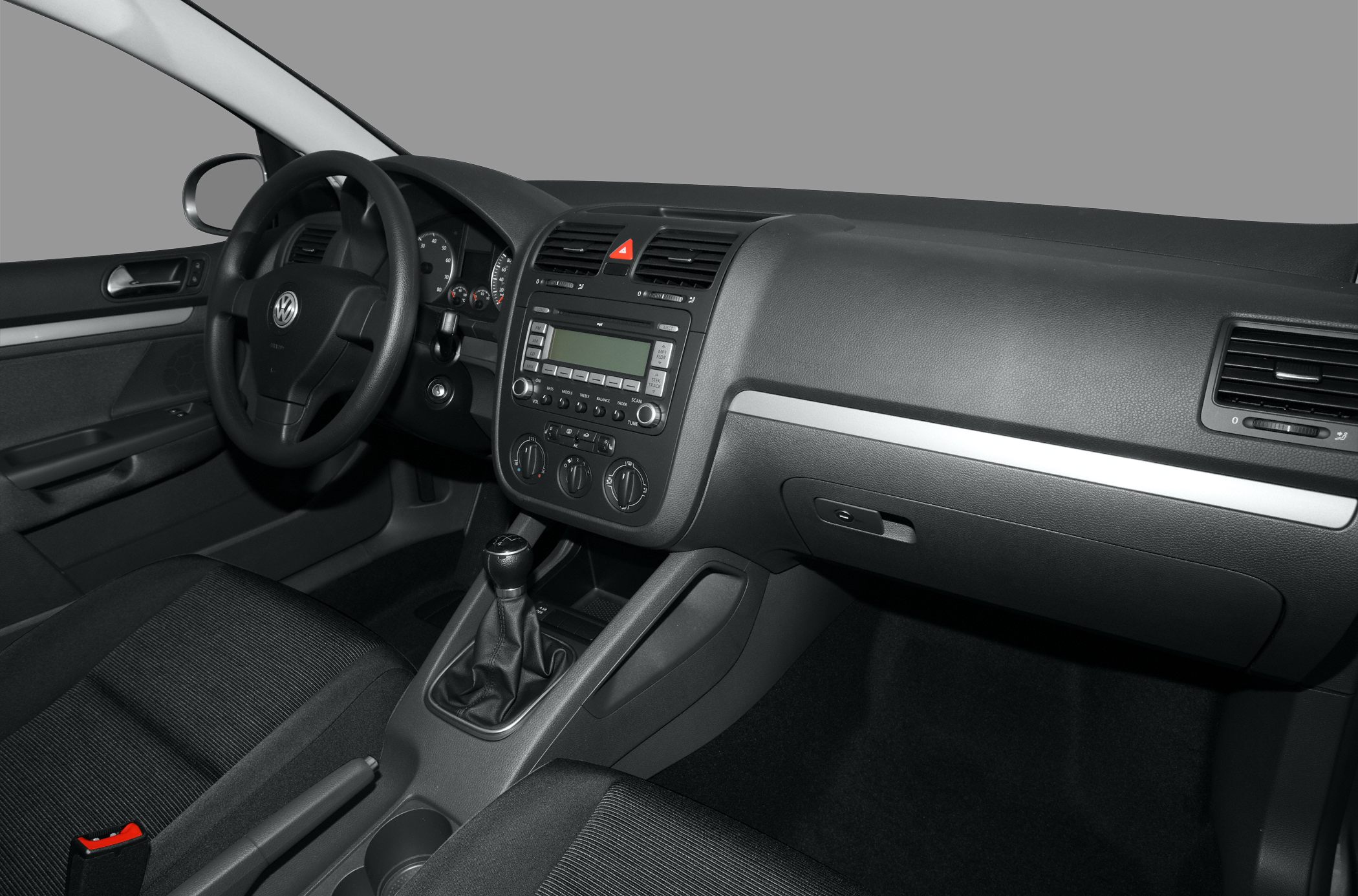 Car interior with dashboard, steering wheel, center console, and manual gear shift