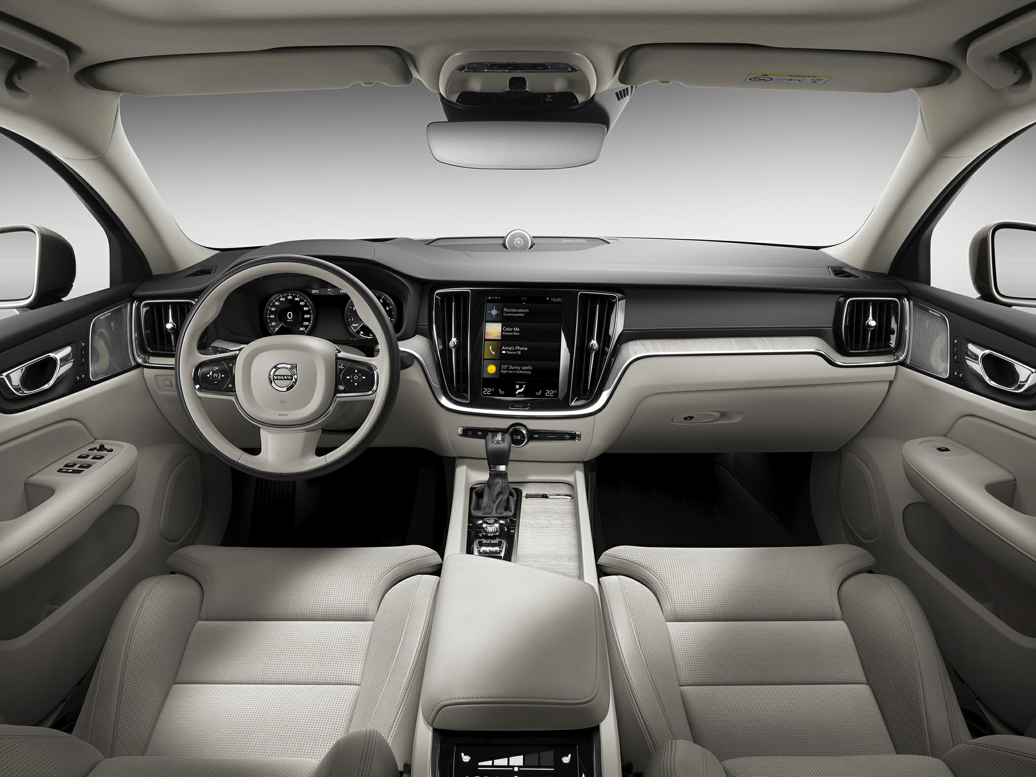 Modern car interior with steering wheel, dashboard, touchscreen, and beige seats