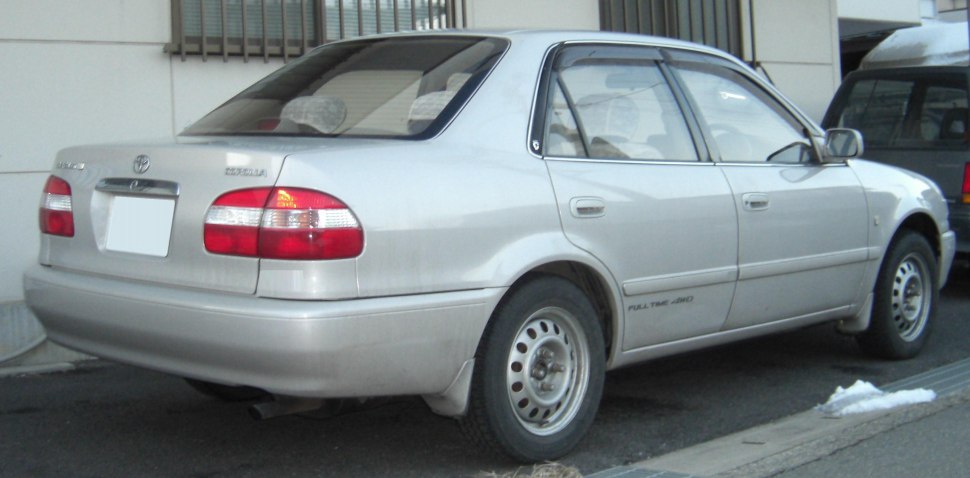Rear-side view of a sedan with steel wheels parked outdoors