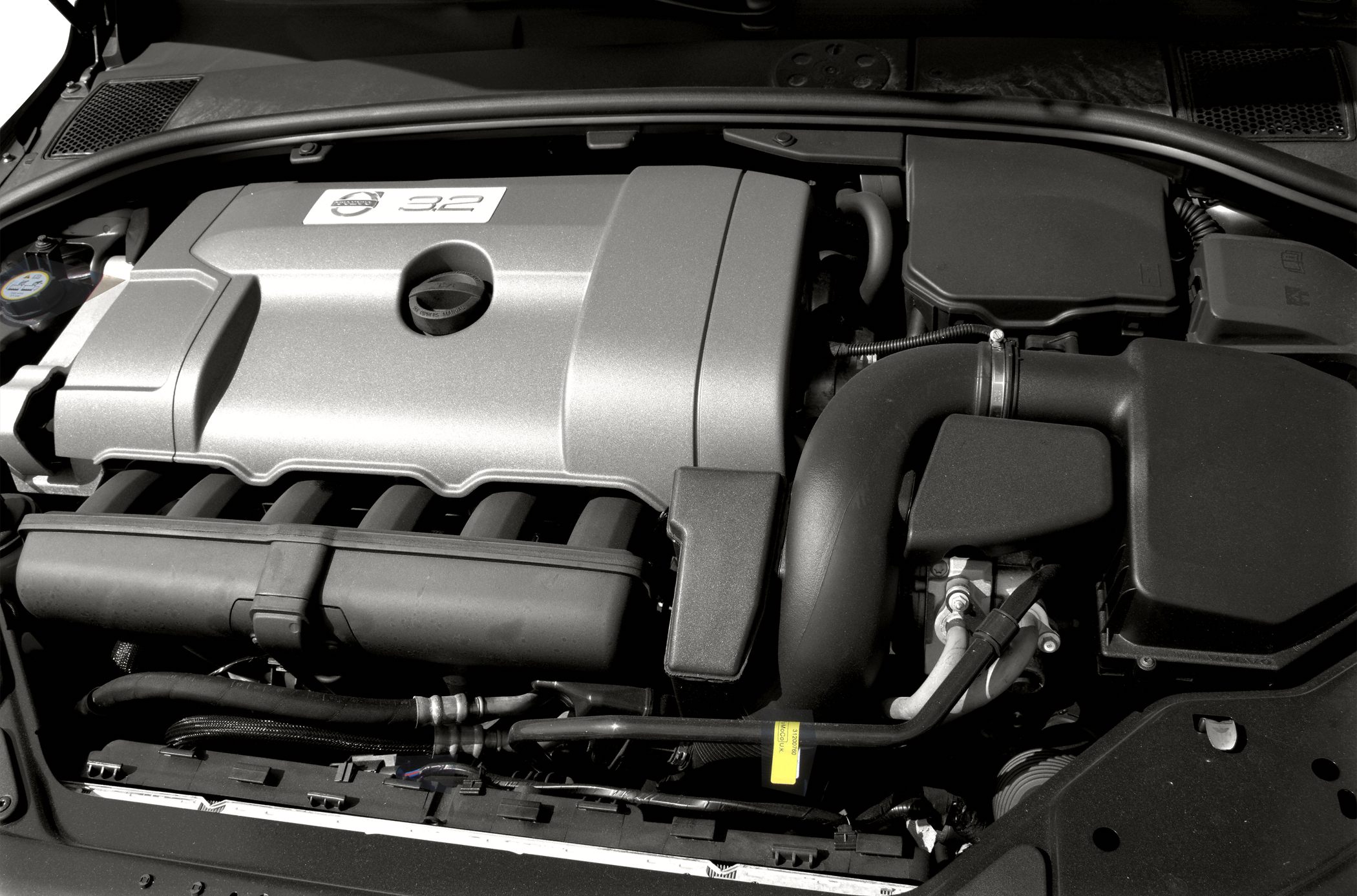 Close-up of engine cover with 3.2L badge and surrounding engine bay components.