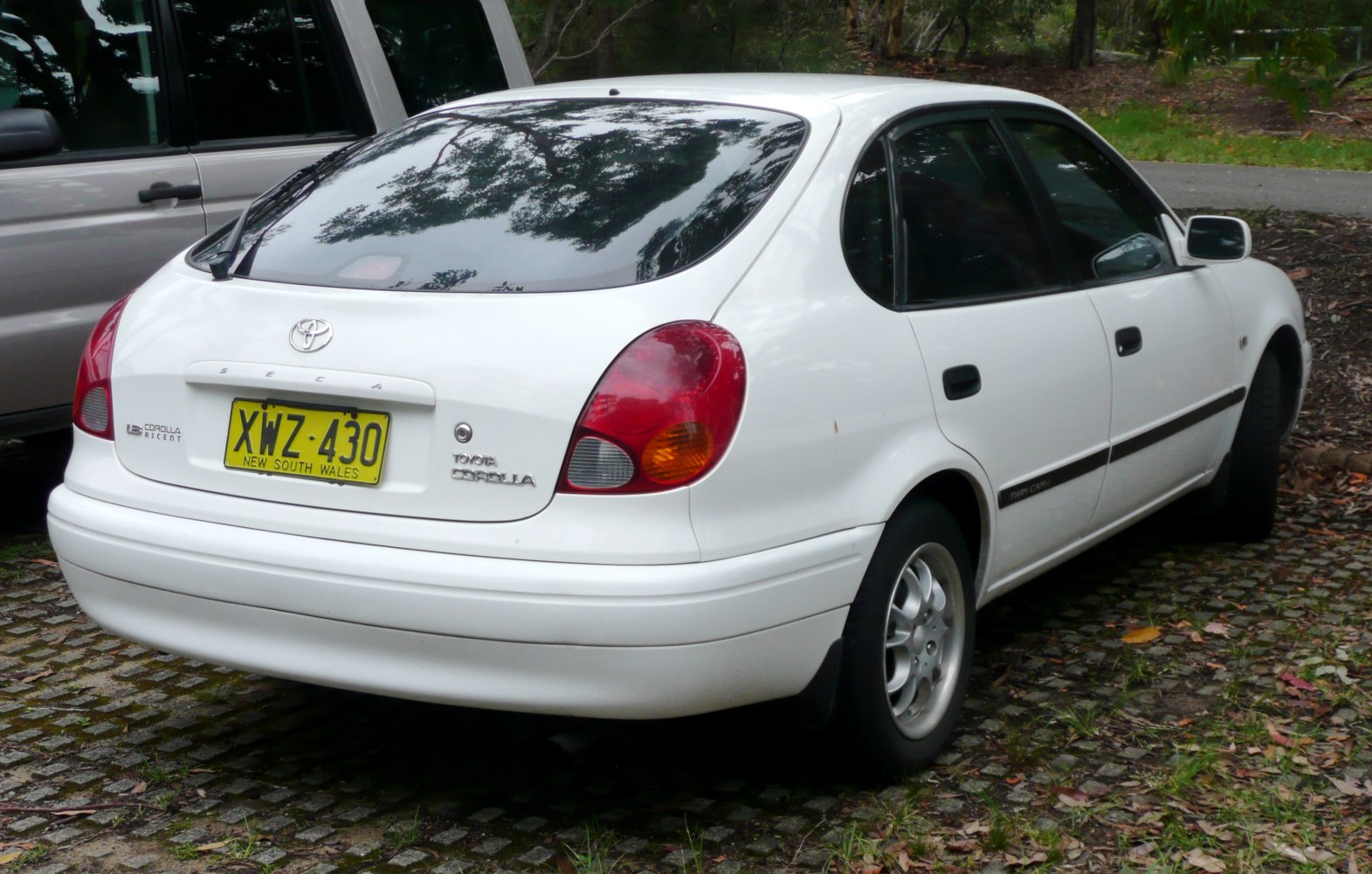 Rear view of white hatchback with distinctive taillights and hatch design