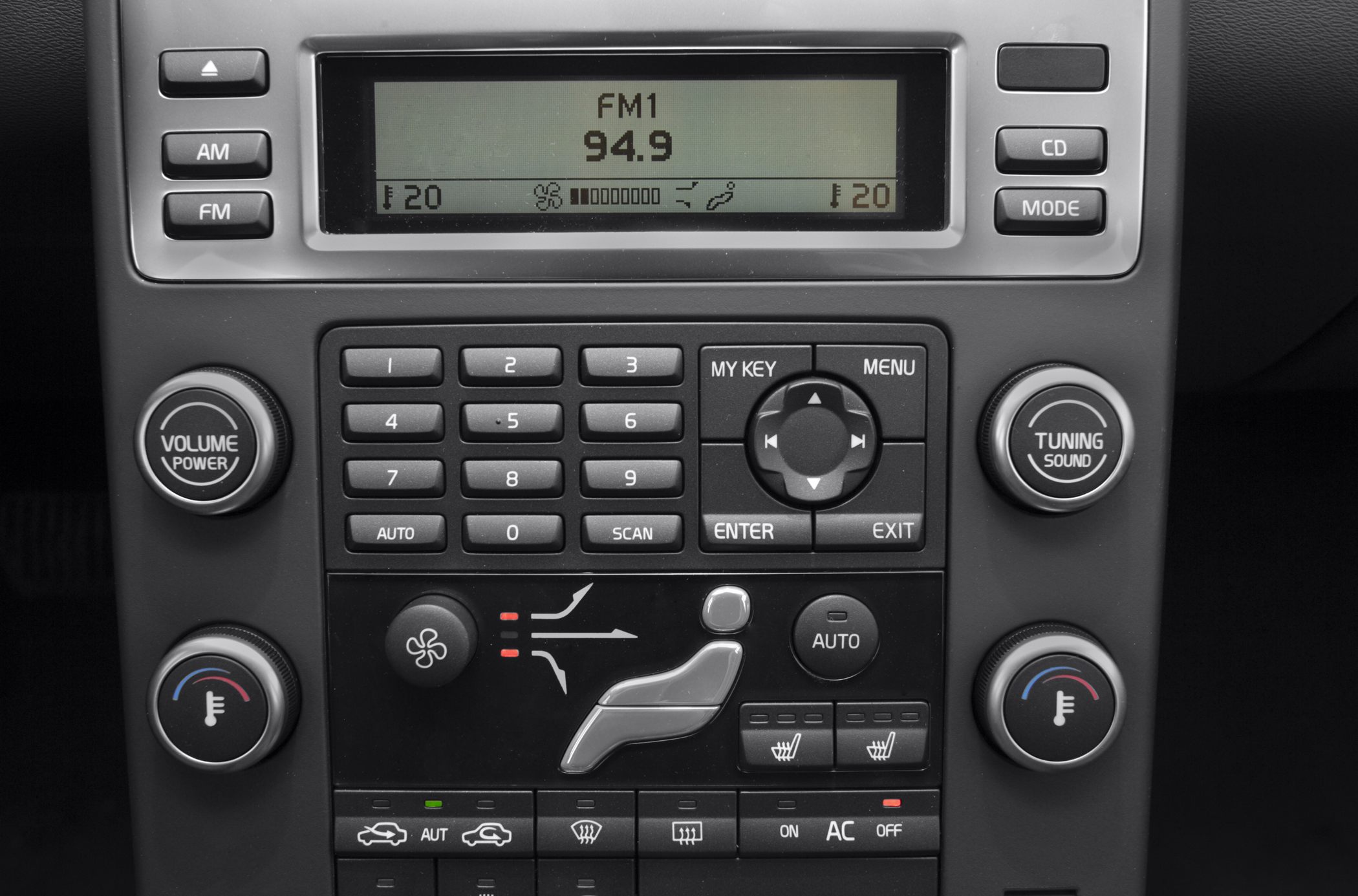 Car audio and climate control panel with buttons, dials, LCD display