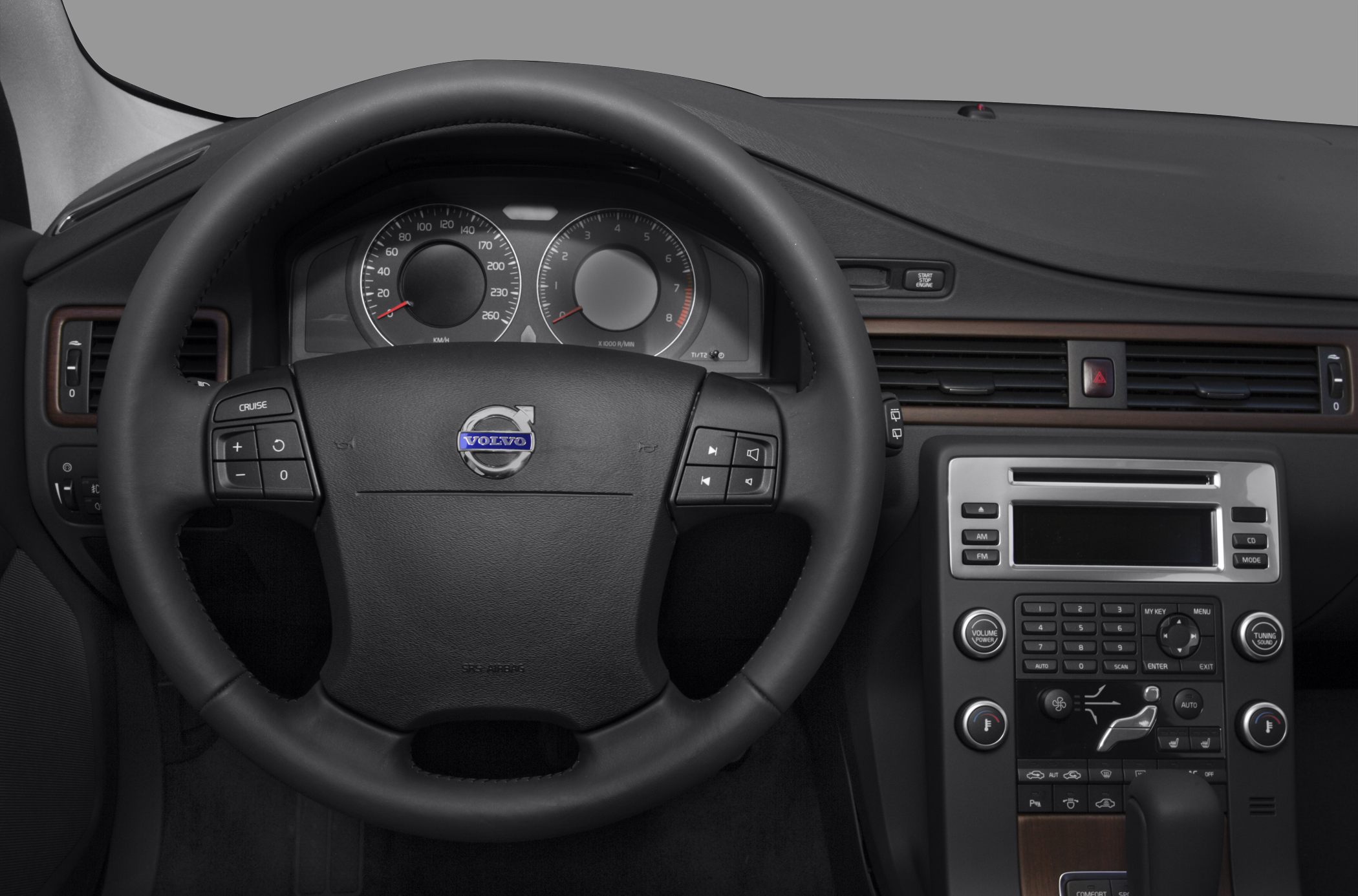 Steering wheel with controls and central dashboard panel with wood trim