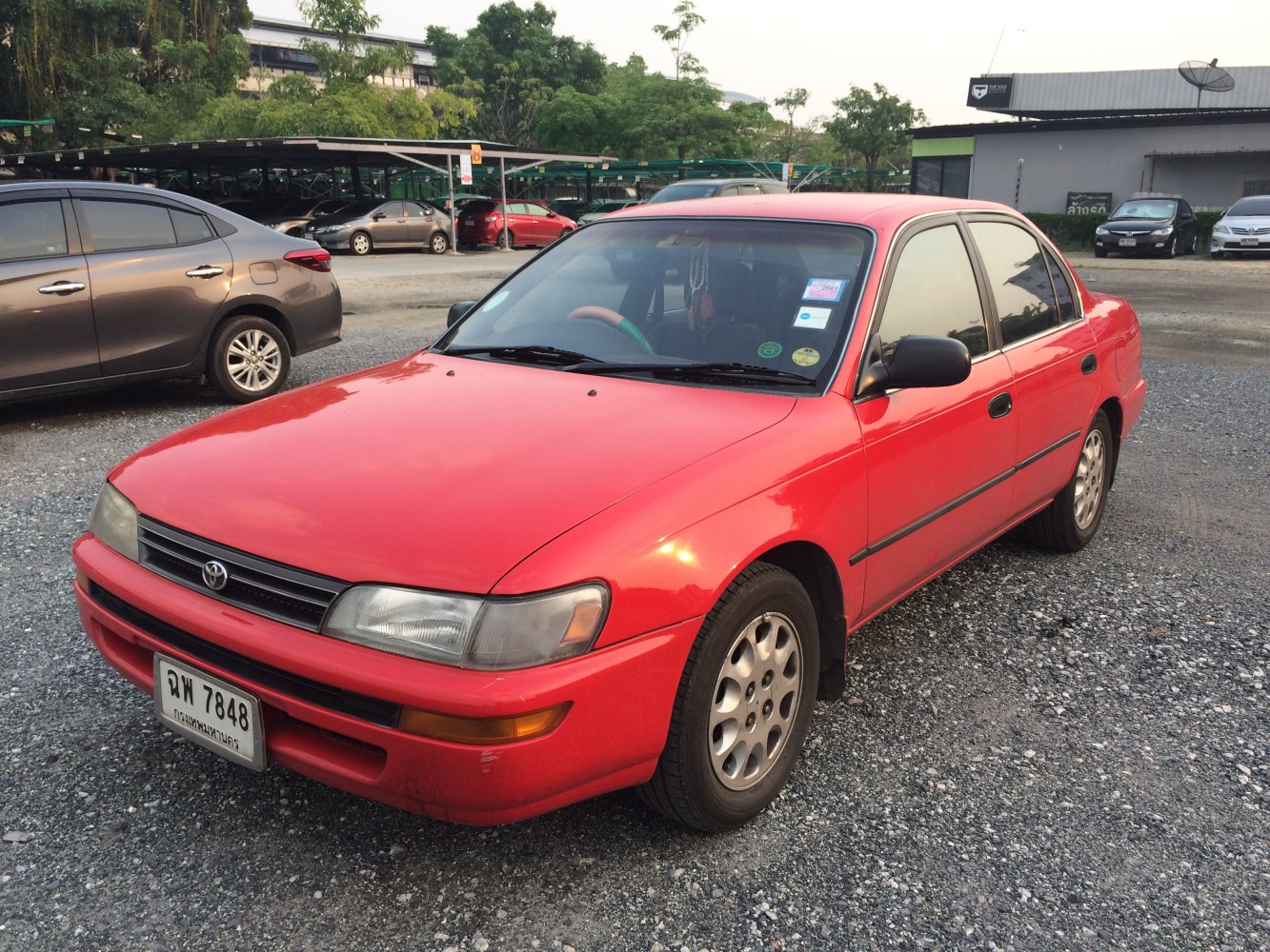 Red sedan with alloy wheels and black side strips