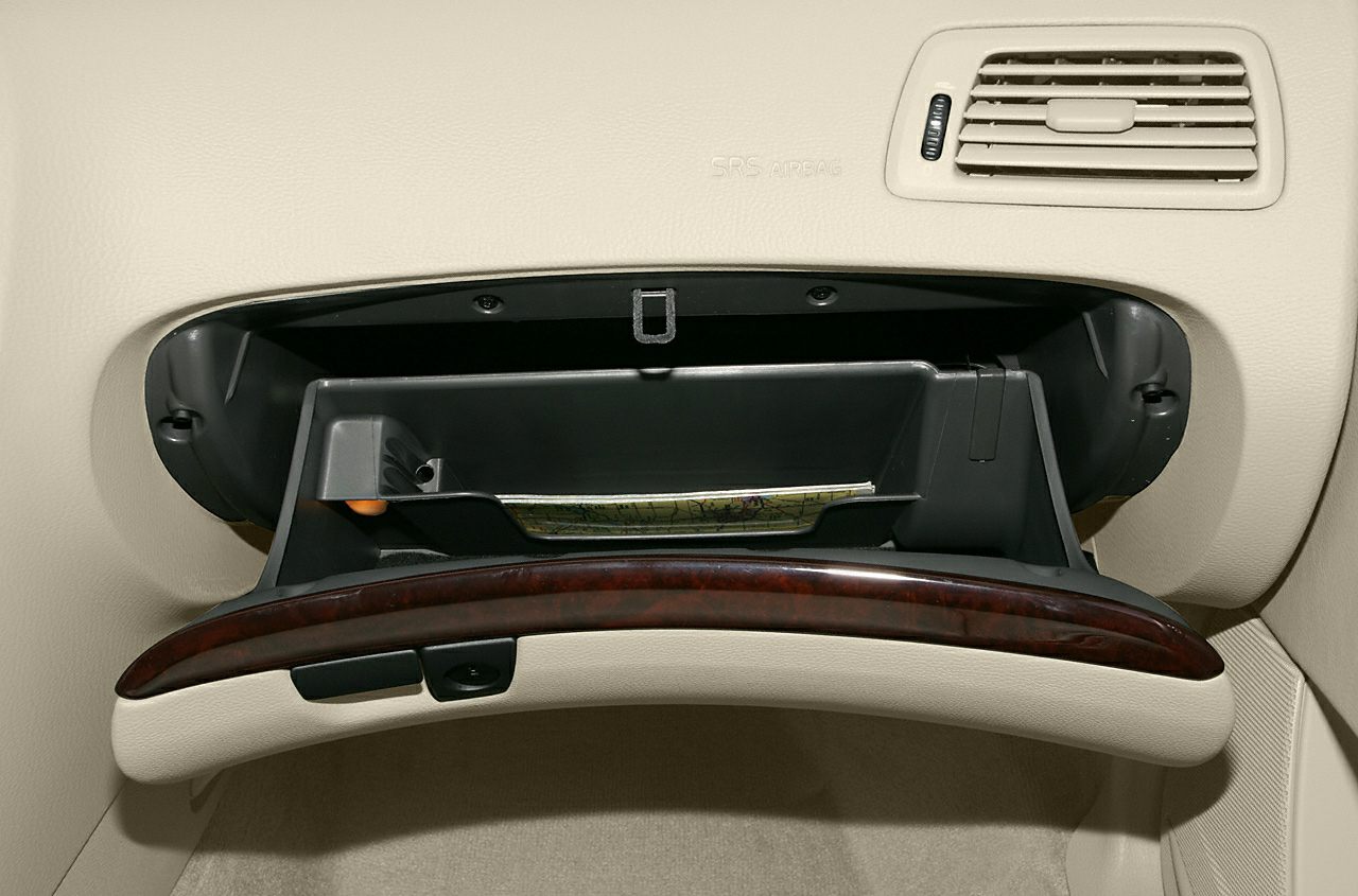 Open glove compartment with dashboard air vent in beige interior