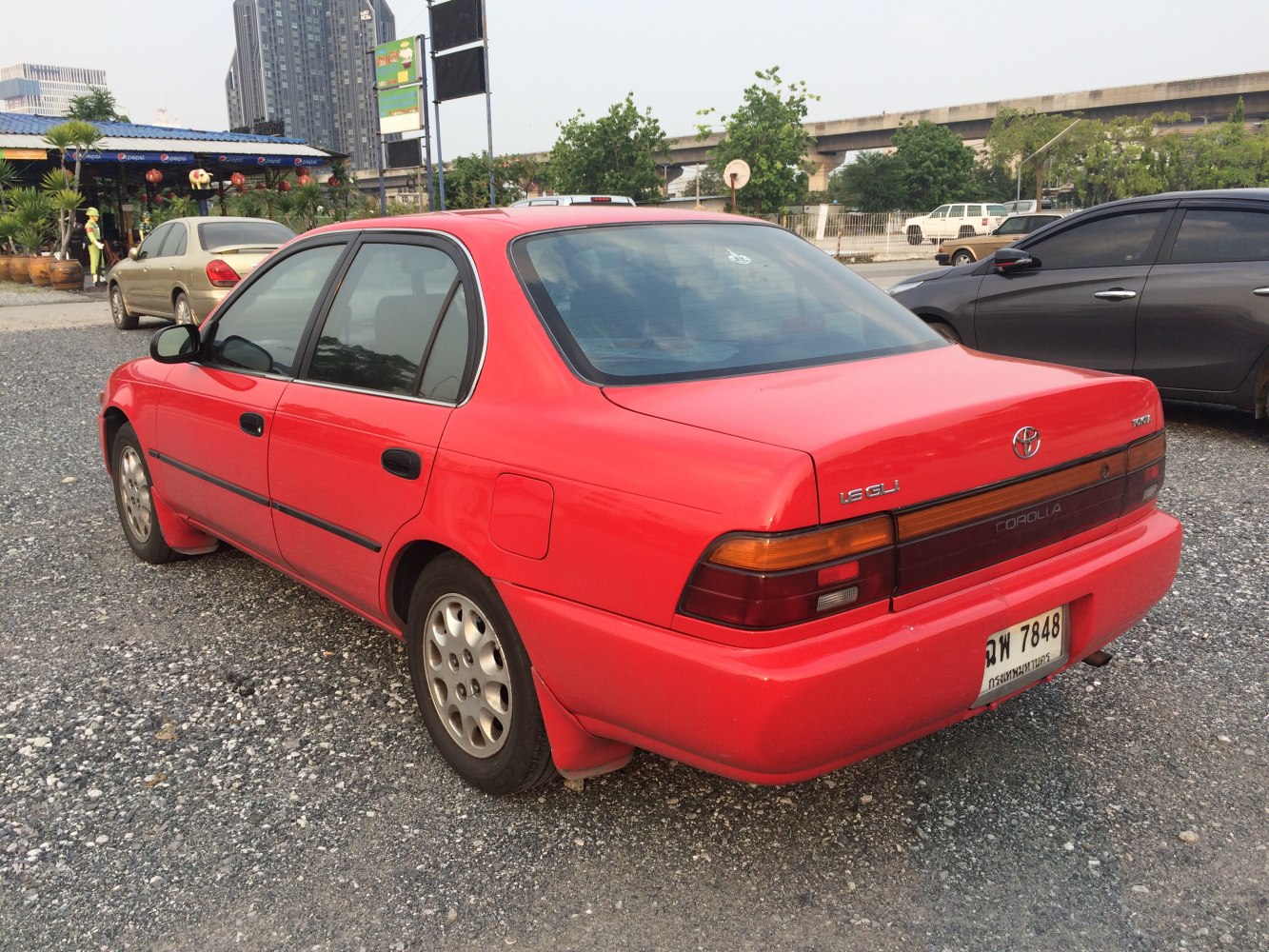 Red sedan rear and side view with distinctive tail lights and smooth body lines