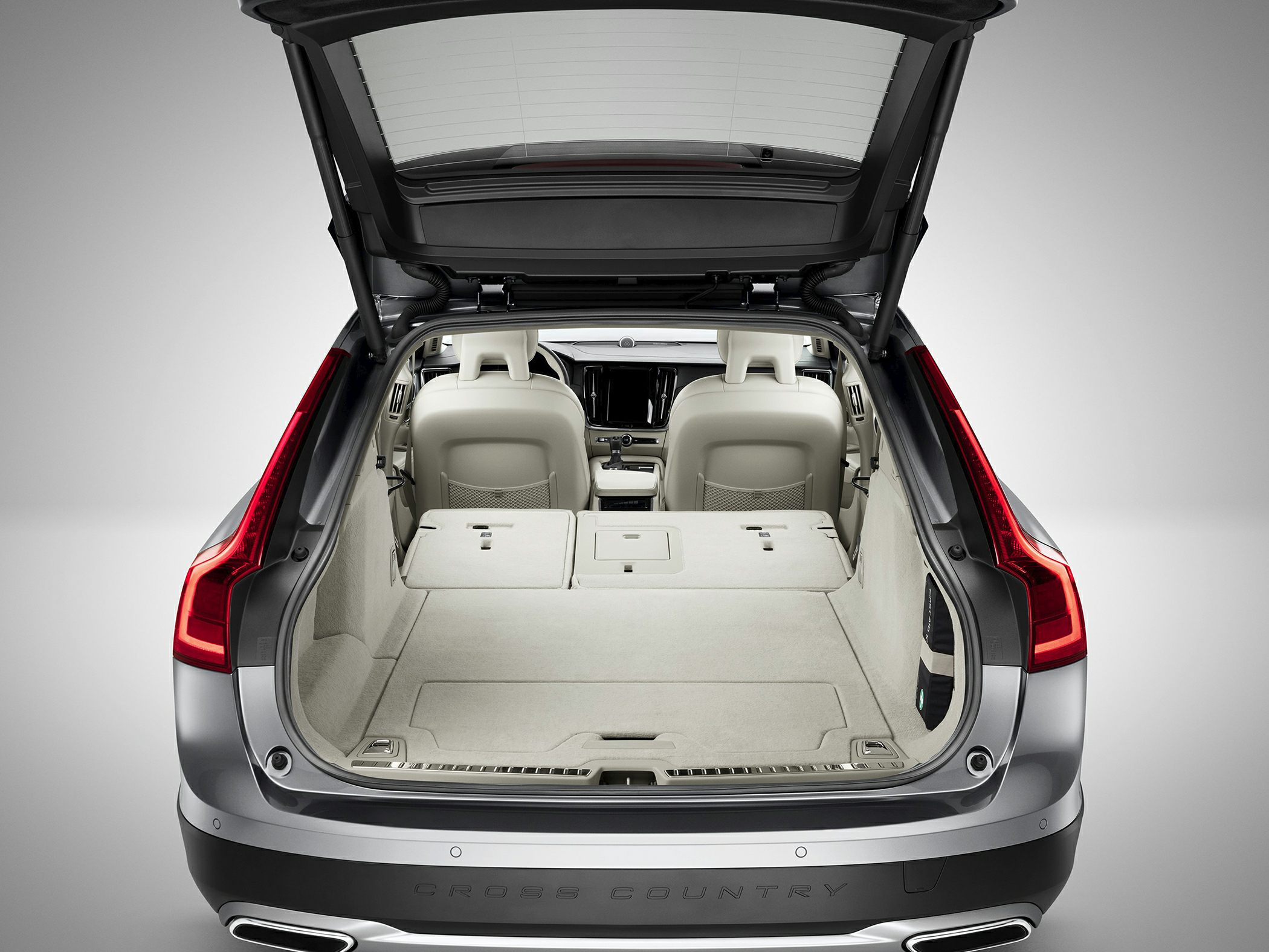 Opened rear hatch with large cargo space and folded rear seats.