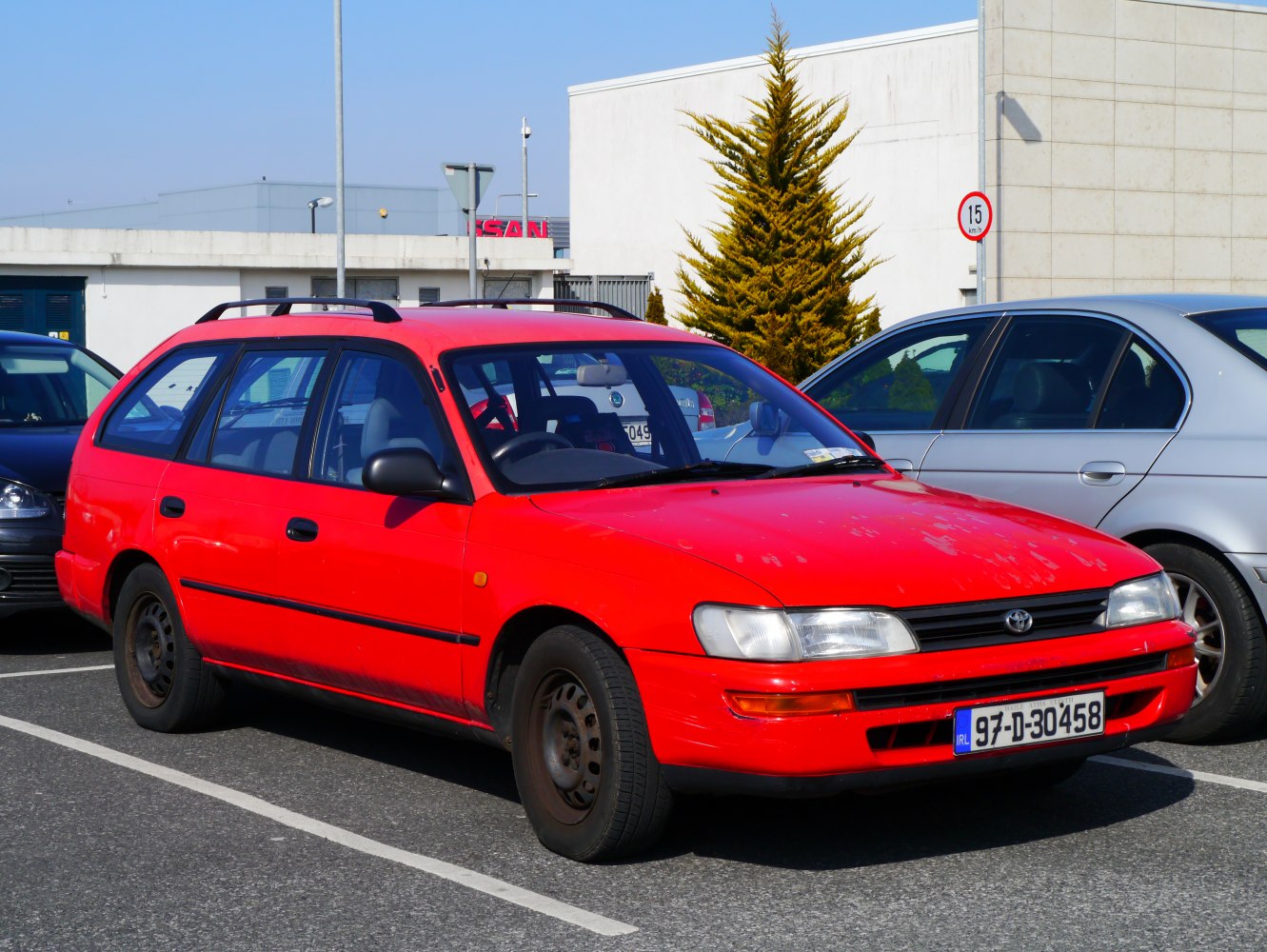 Red station wagon with roof rails, front and side visible