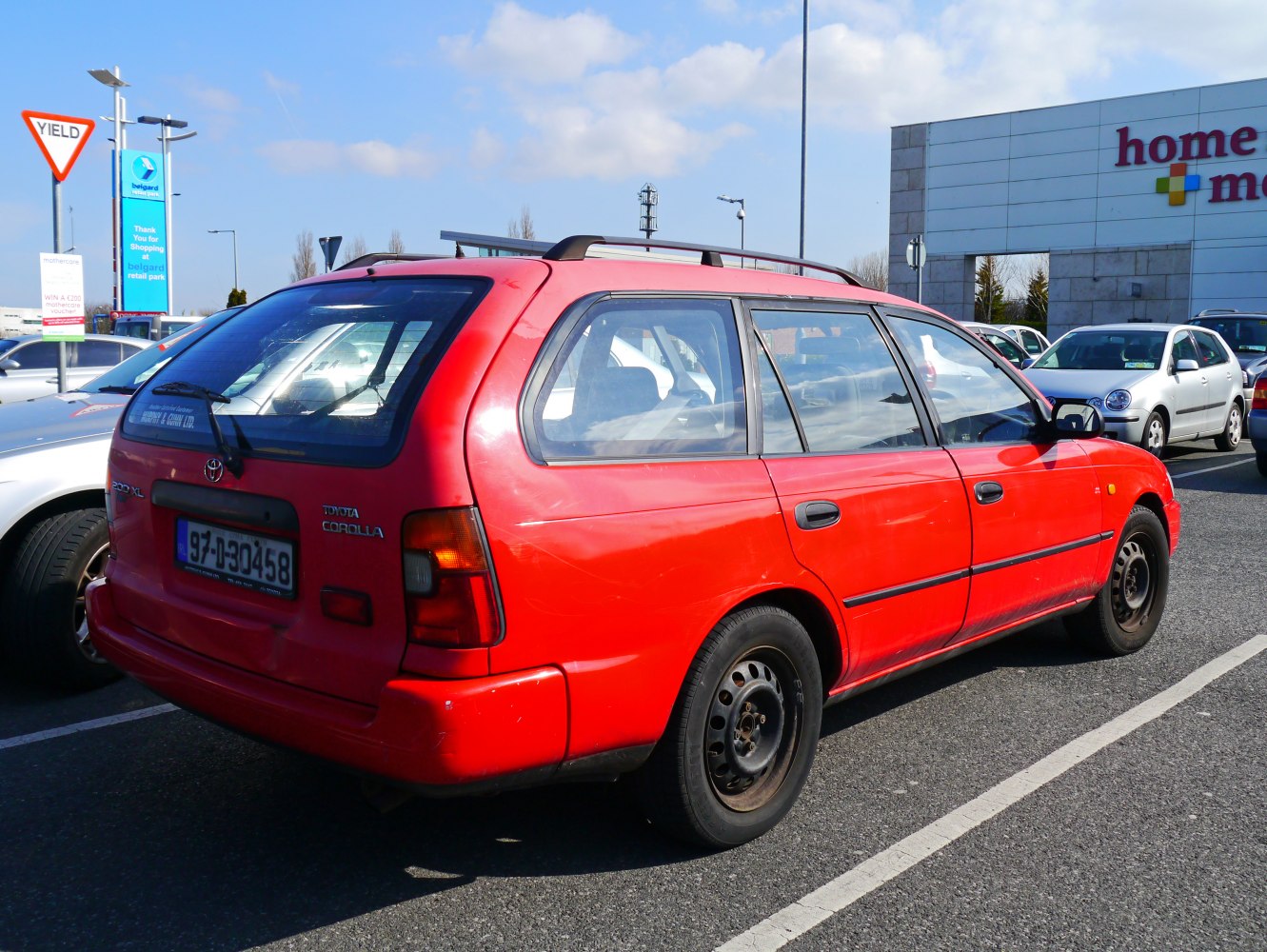 Red station wagon with roof rails and rear side view