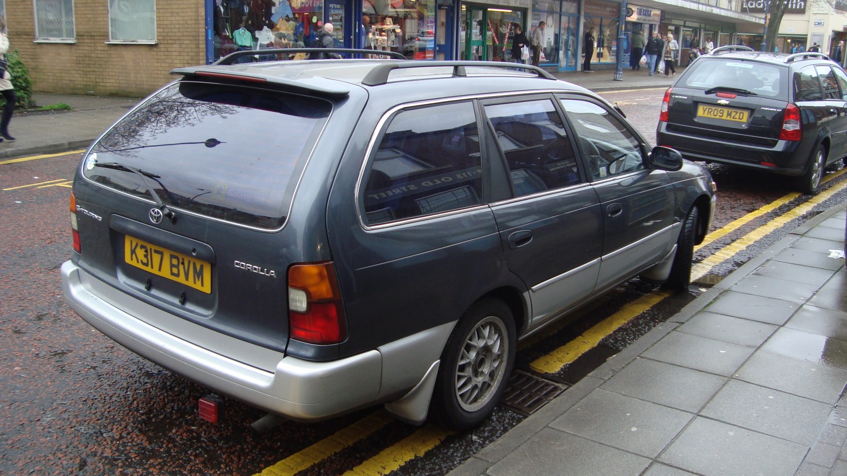 Rear and side of 1990s wagon with roof rails and alloy wheels