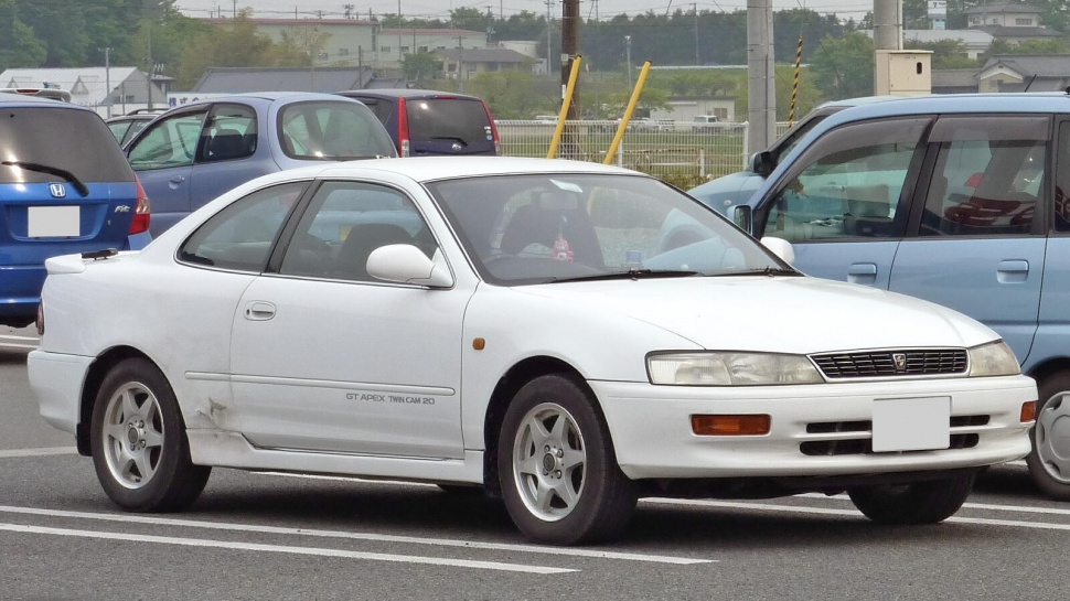 White compact coupe with rear spoiler and alloy wheels