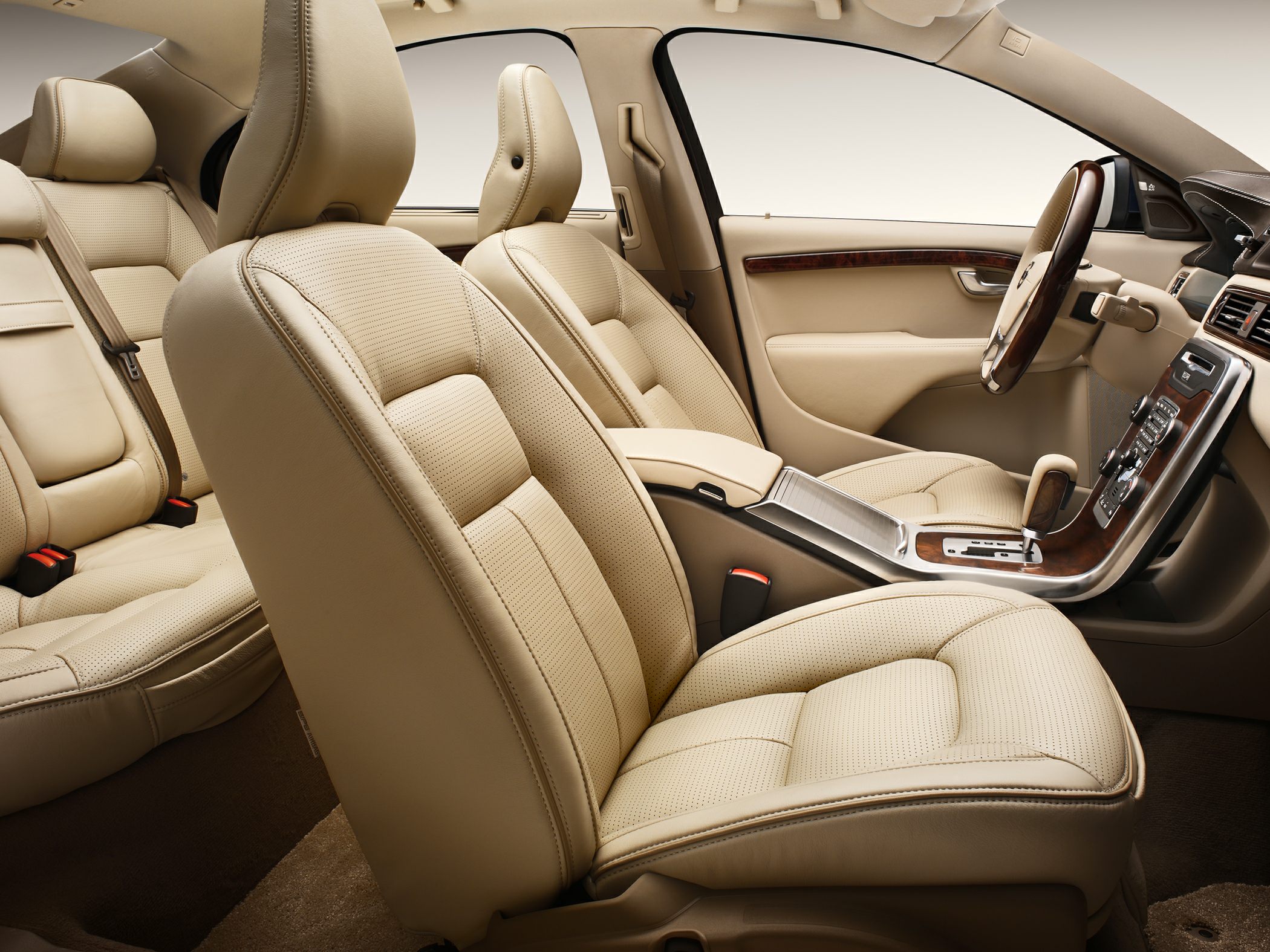 Beige leather seats with perforation and wood trim on dashboard and console