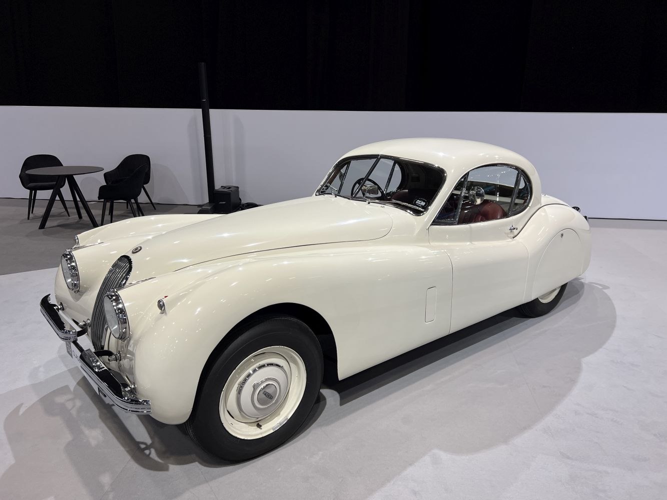 Smooth curved front, classic chrome grille, rounded fenders, vintage coupe design