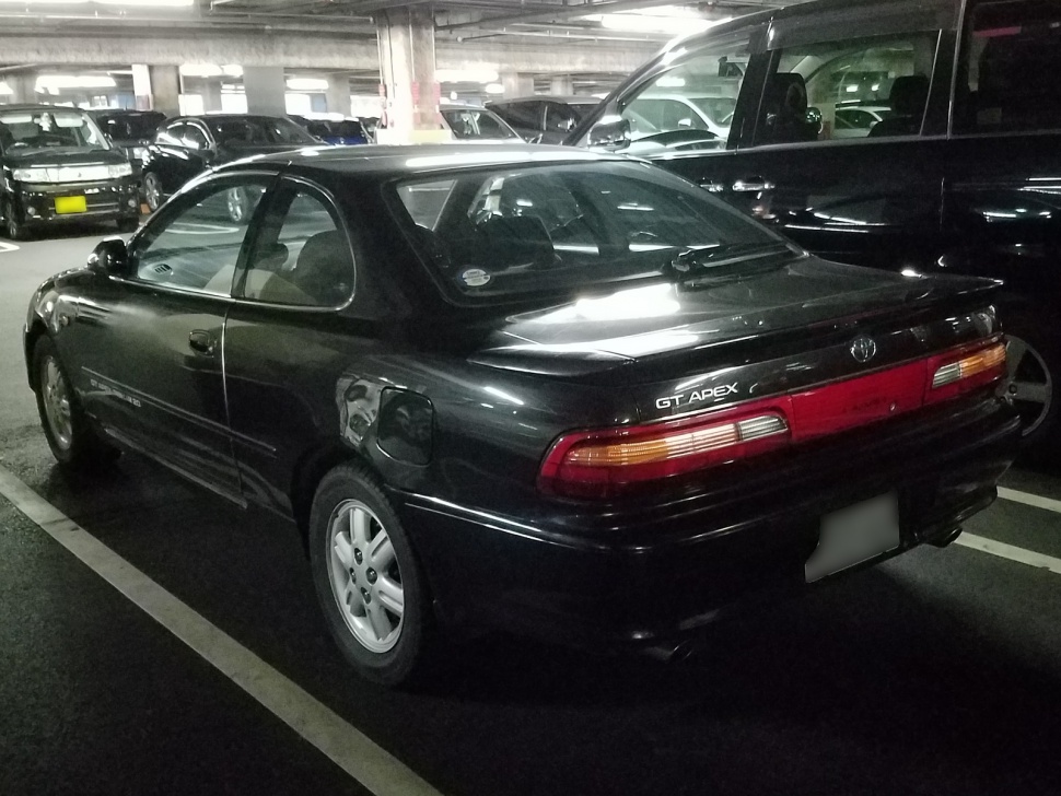 Rear side view of a 1992 coupe with distinct taillights in a parking garage