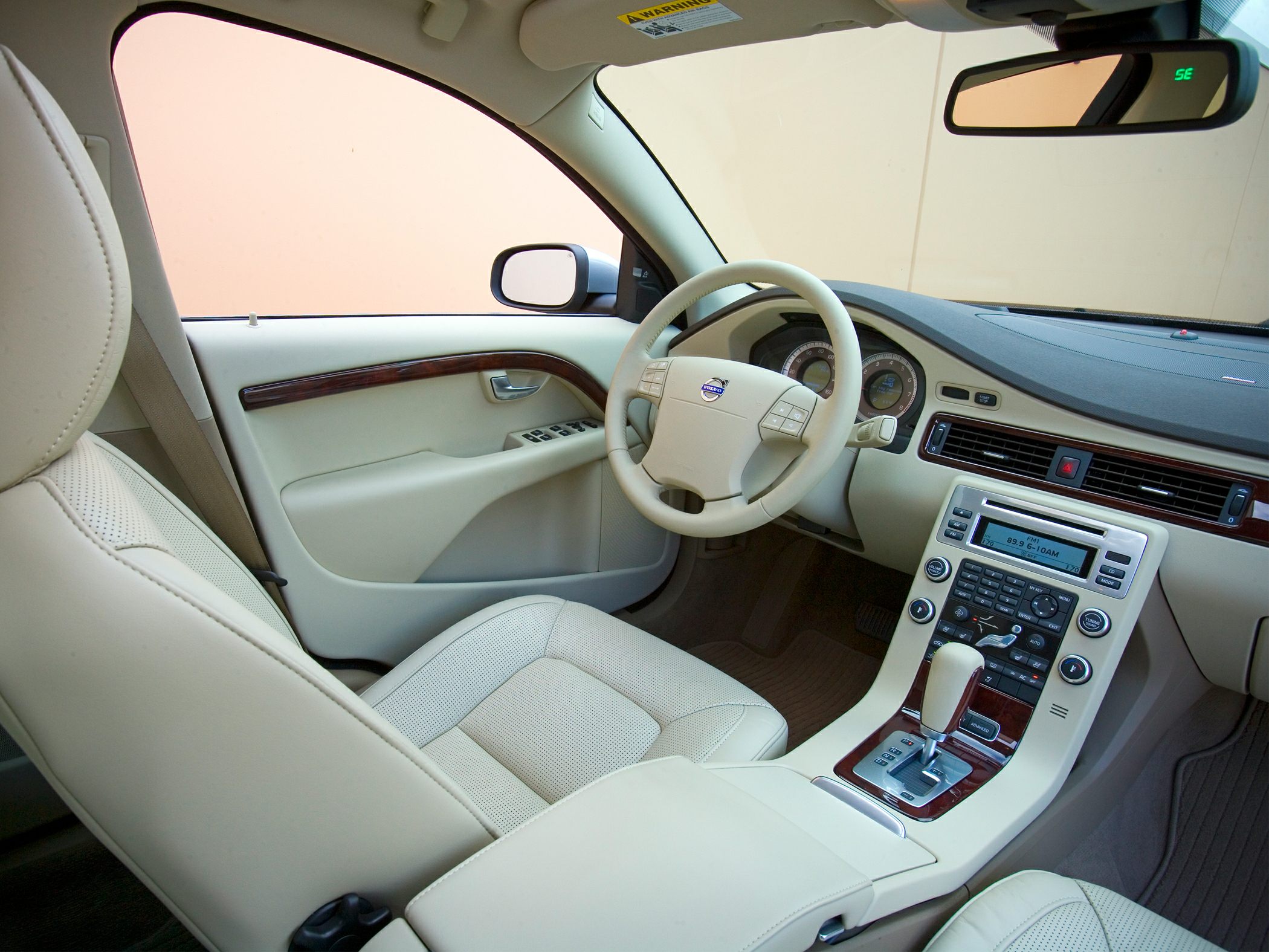 Beige leather interior with wooden trim and dashboard controls