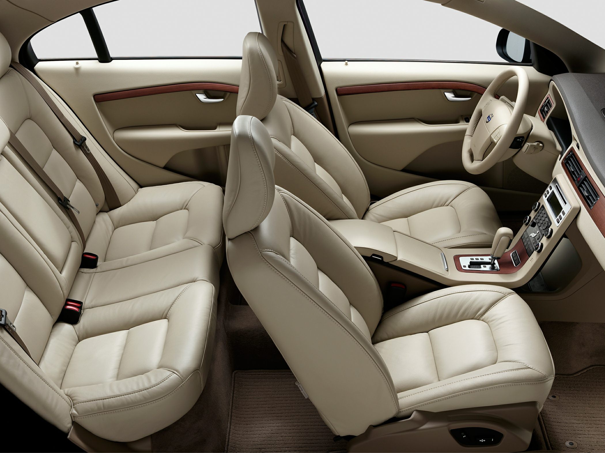 Beige leather car interior with wood trim and ergonomic seats.