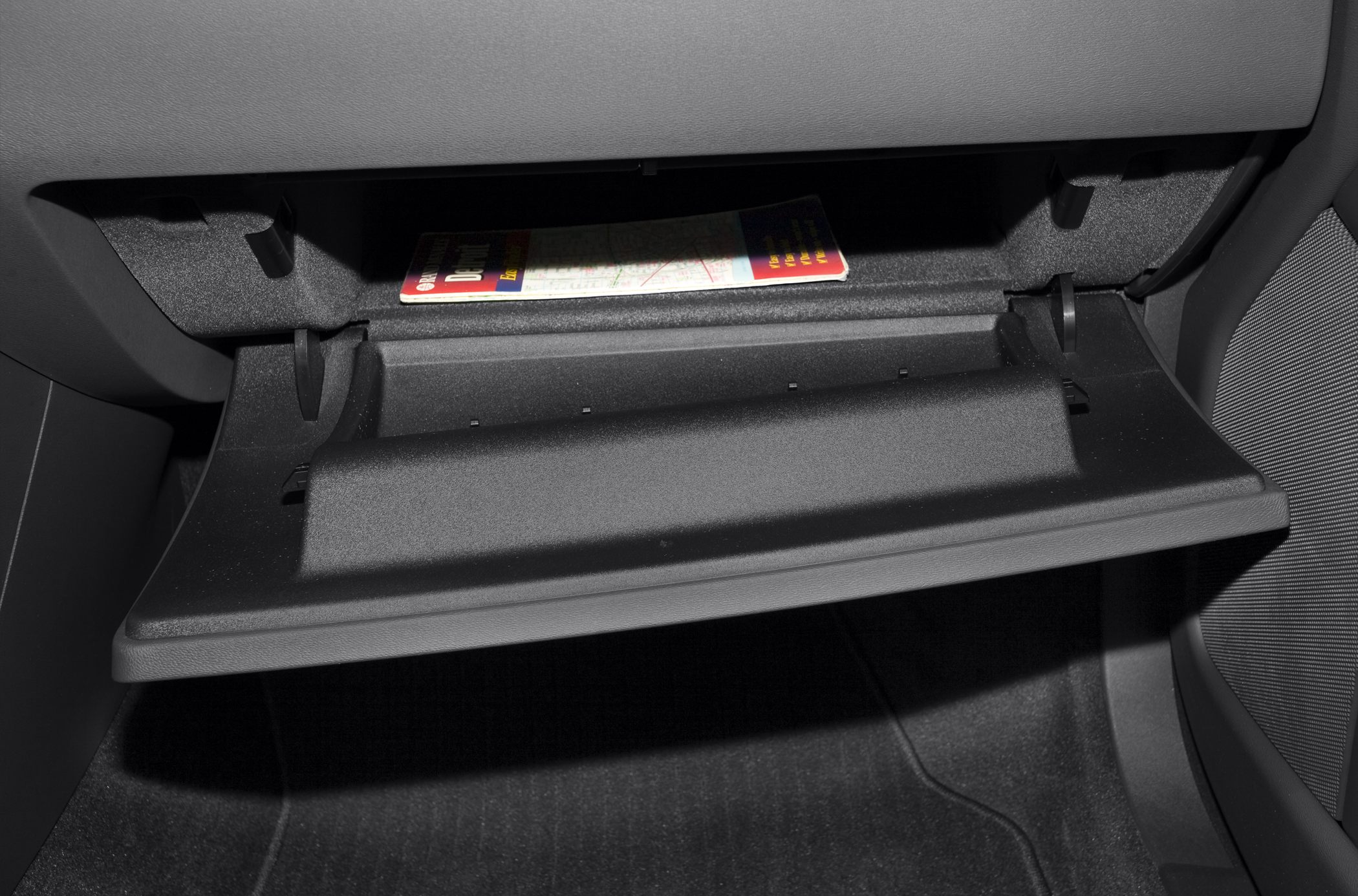 Open glove compartment interior with map inside