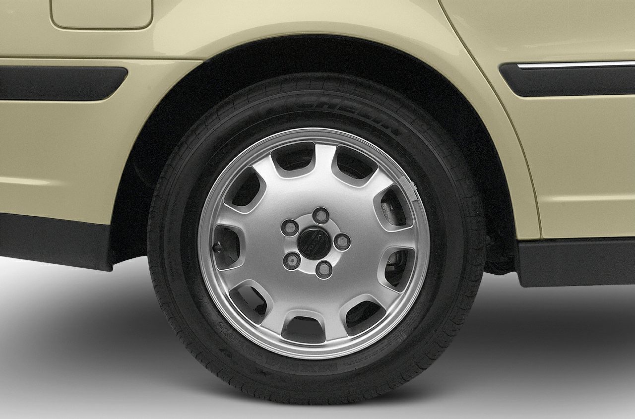 Close-up of sedan wheel and tire with beige body panel