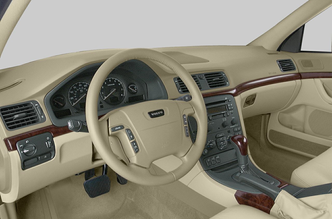 Beige dashboard and steering wheel with wood trim and control buttons