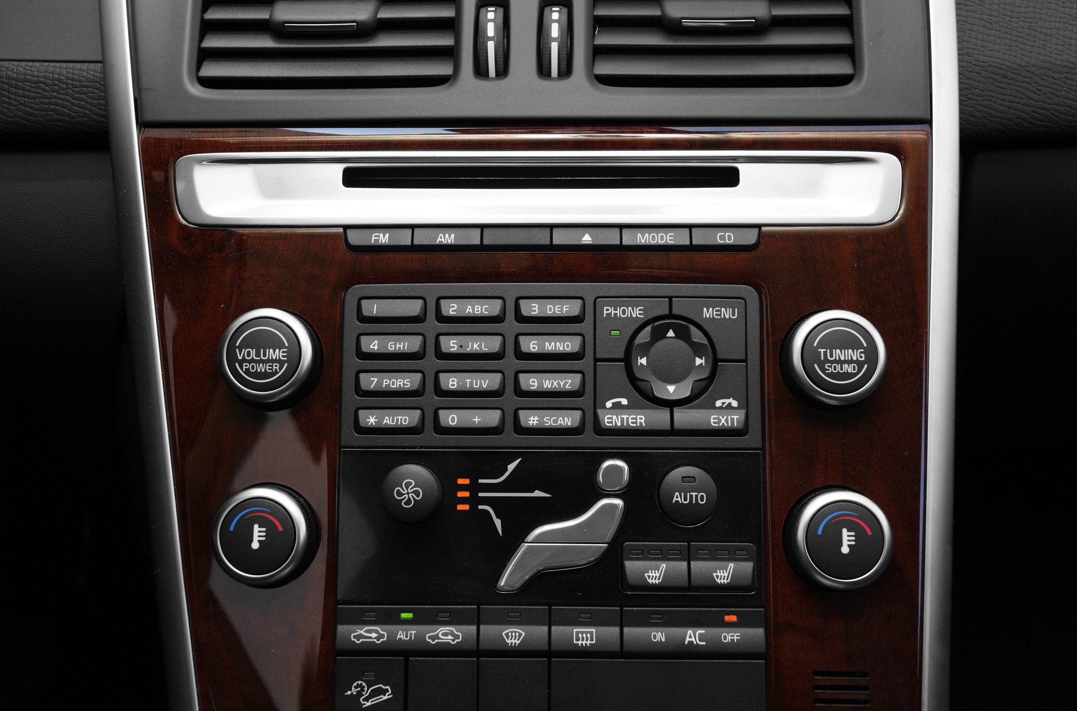Center console with audio and climate control panel, wood trim, knobs, and buttons