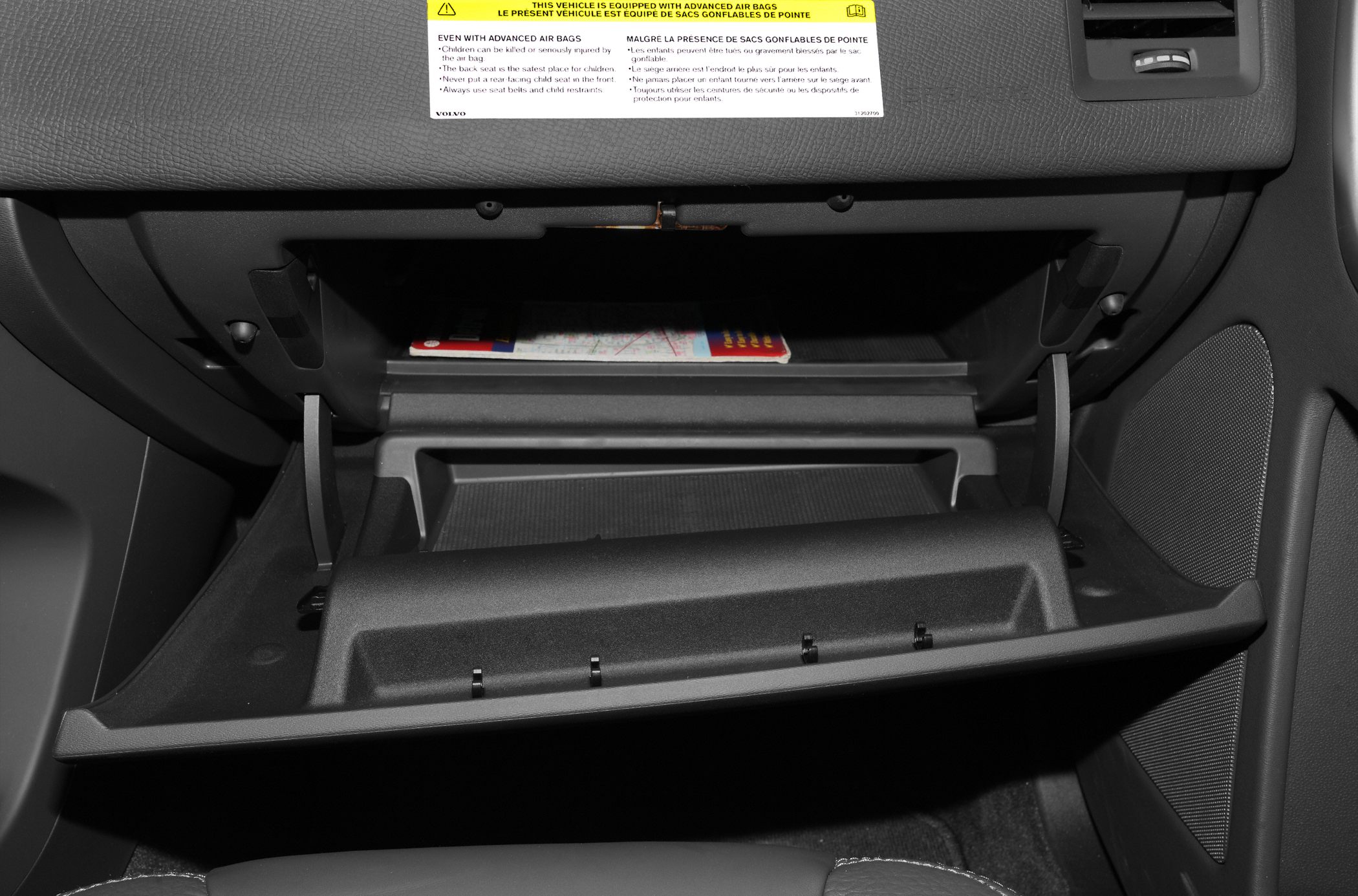 Open glove compartment interior with airbag warning label