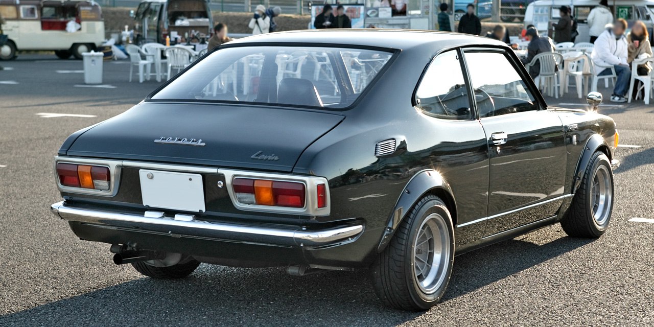 Rear view of a vintage compact coupe with classic taillights, flared wheel arches, and sporty lines.