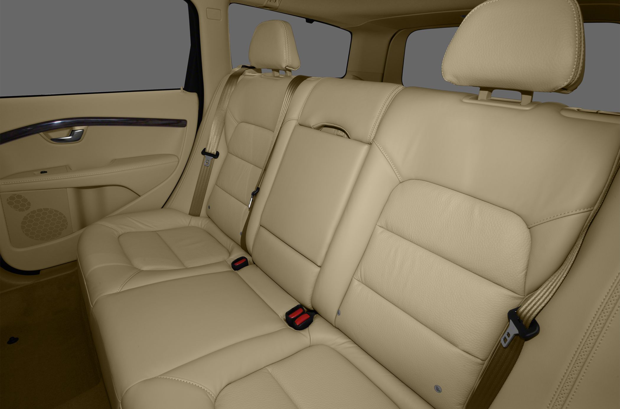 Beige leather rear seating with headrests and seat belts.