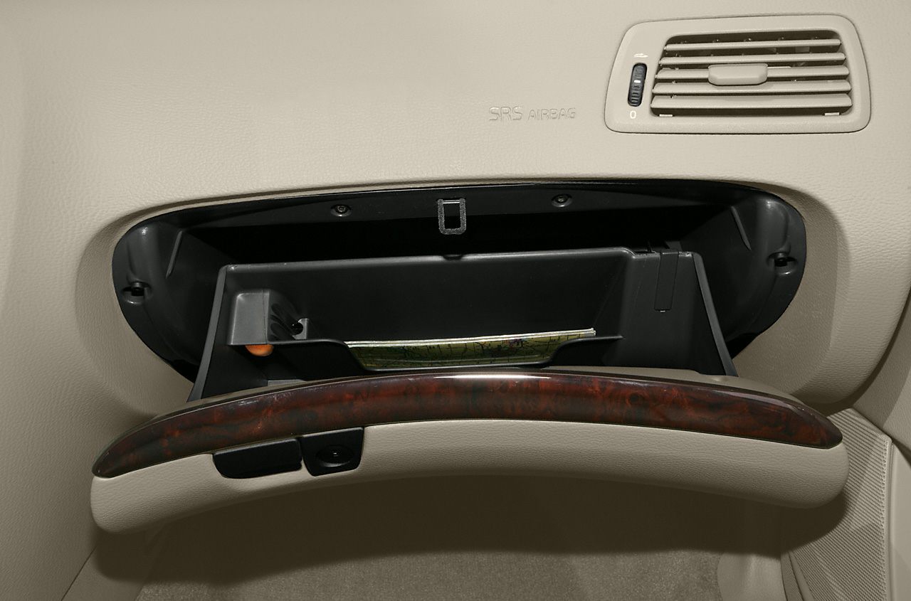 Open glove compartment with wood trim on beige dashboard