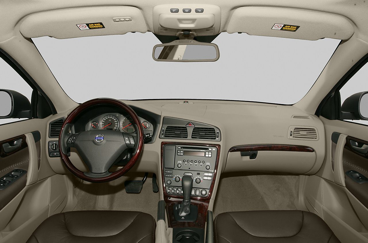 Beige interior with wooden trim, dashboard, steering wheel, center console with controls
