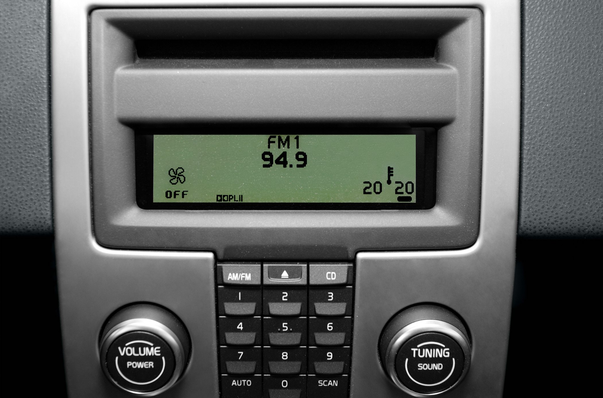 Car radio and climate control panel with FM display and knobs