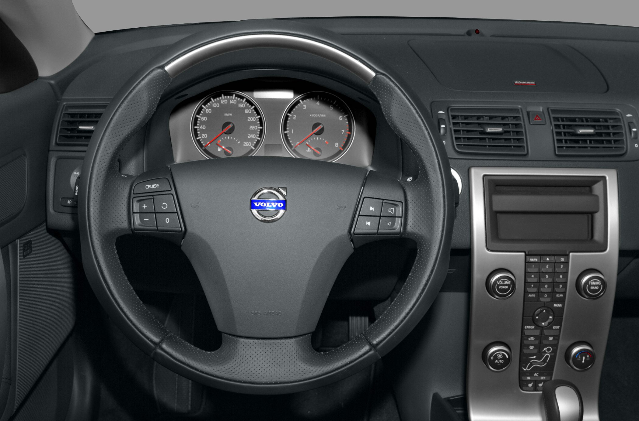 Steering wheel with cruise and audio controls, dashboard with speedometer and climate control.