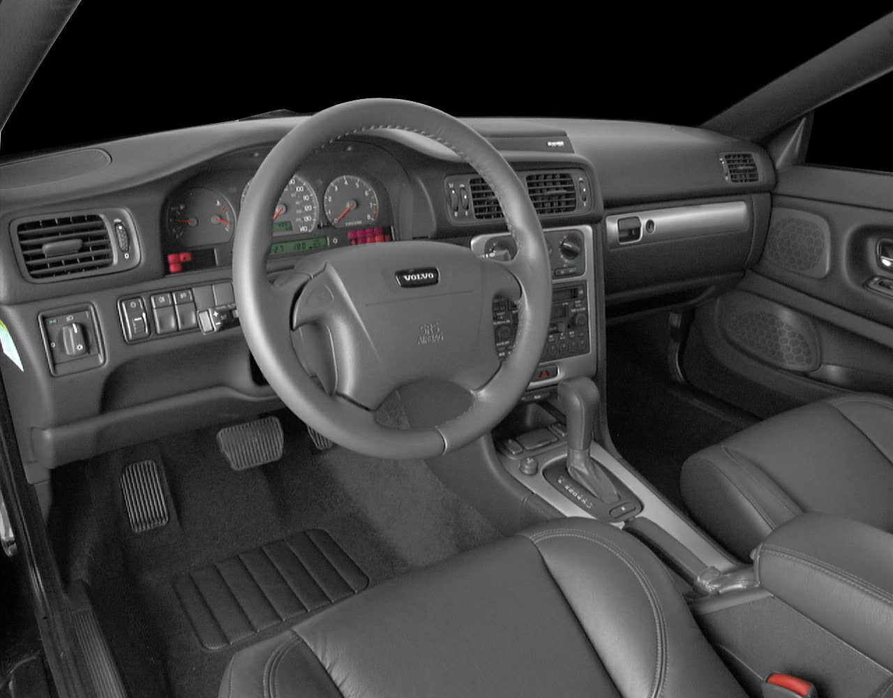 Dashboard, steering wheel, center console, pedals, and leather seats interior view