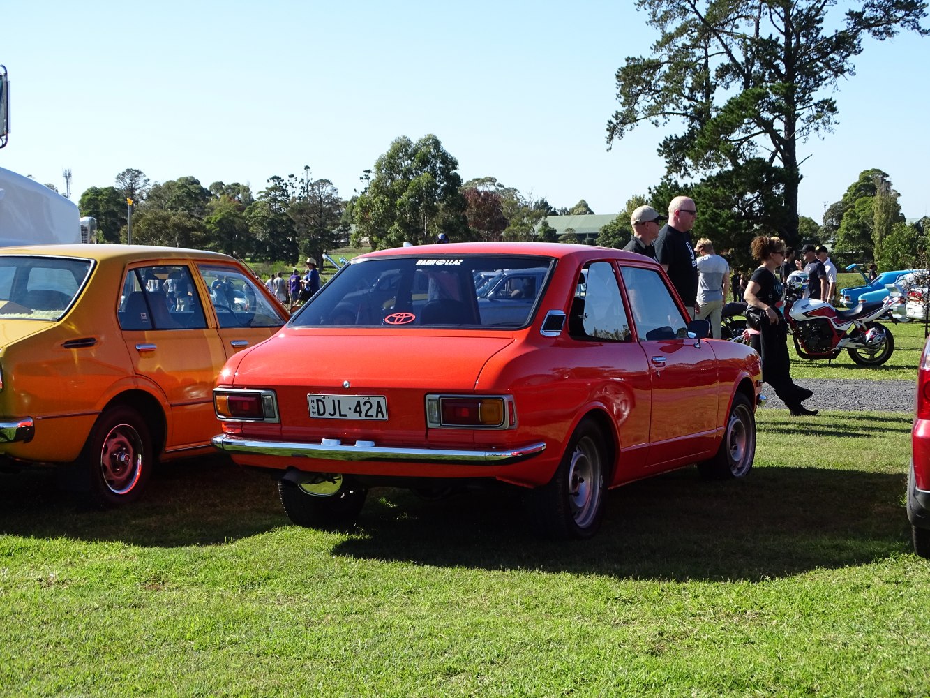 Classic compact 2-door sedan rear with rectangular taillights and chrome bumper.