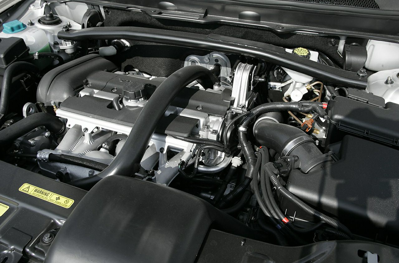 Engine bay with intake, hoses, and mechanical components.
