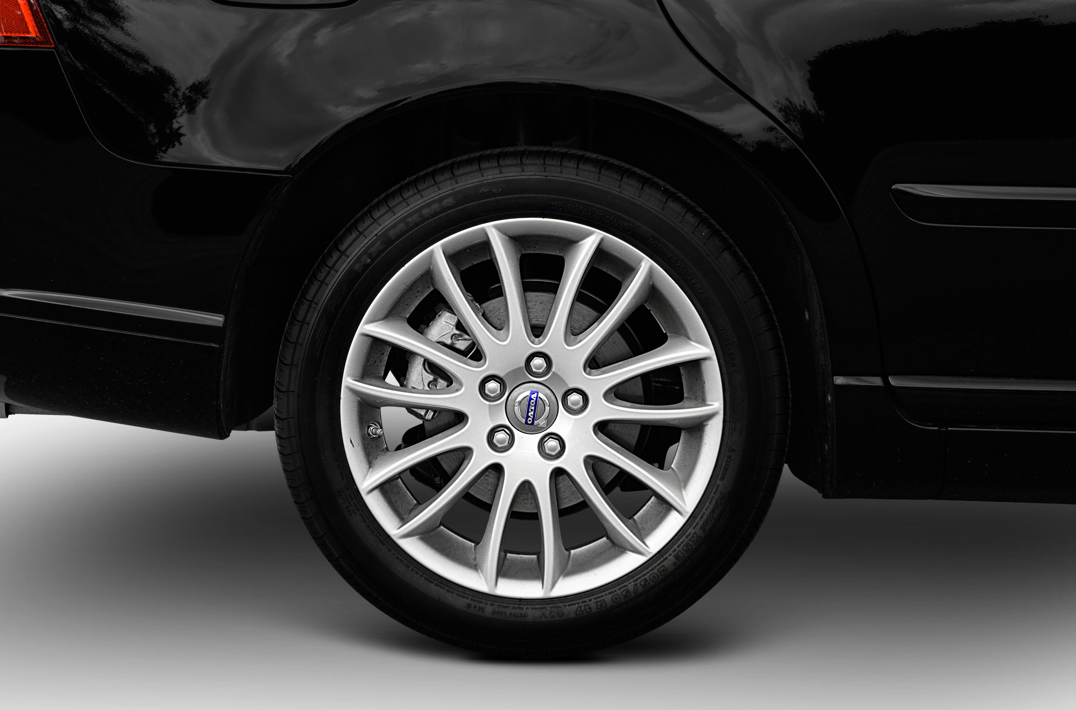 Multi-spoke alloy wheel with visible brake caliper on car rear side