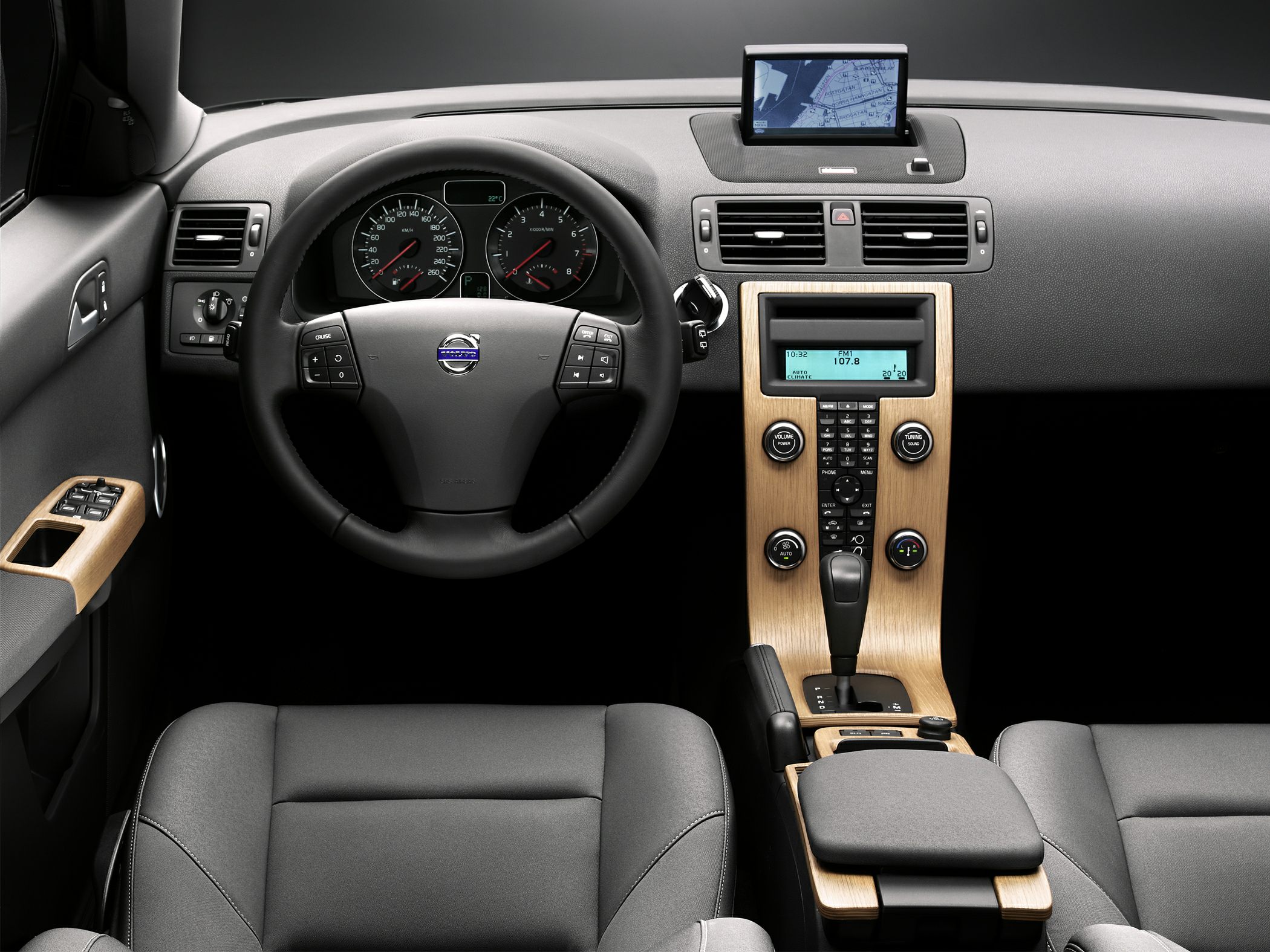 Volvo steering wheel and wood-accented center console with digital display