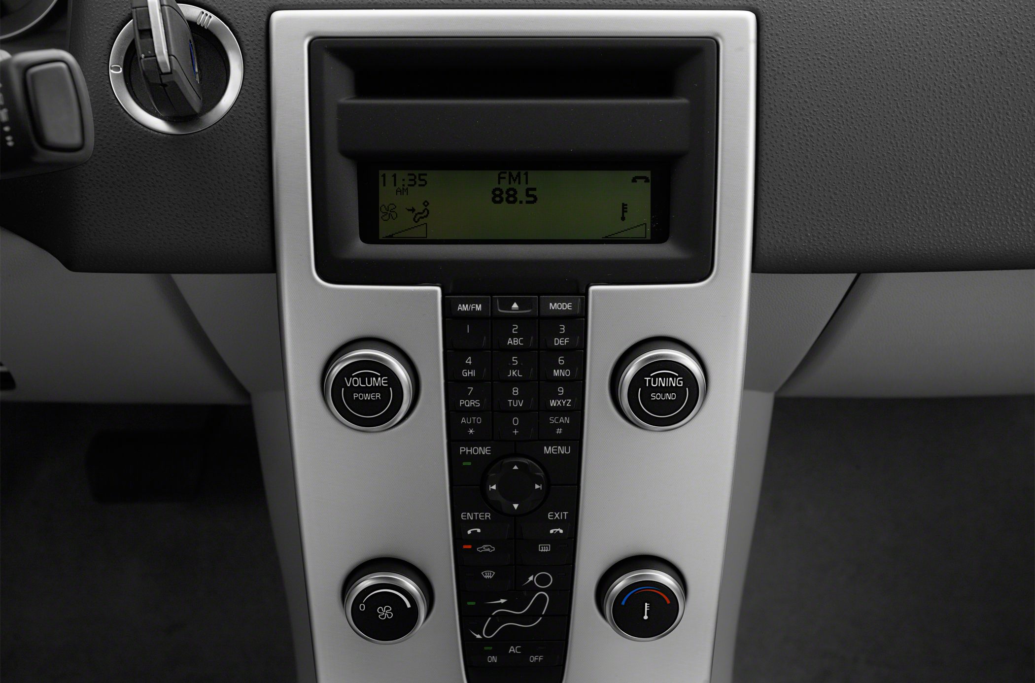 Center console with radio display, tuning and volume knobs, and climate control in a car