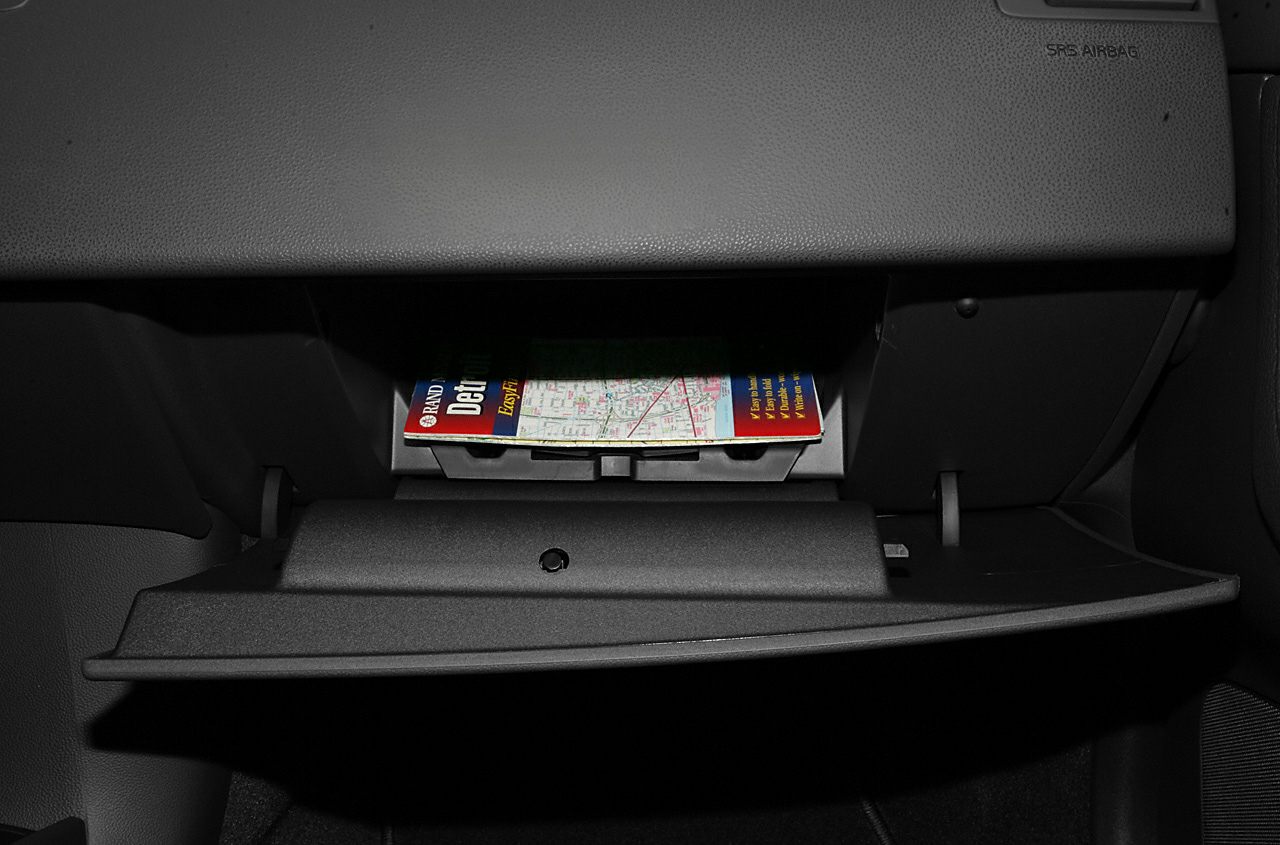 Open glovebox storage compartment with a map inside