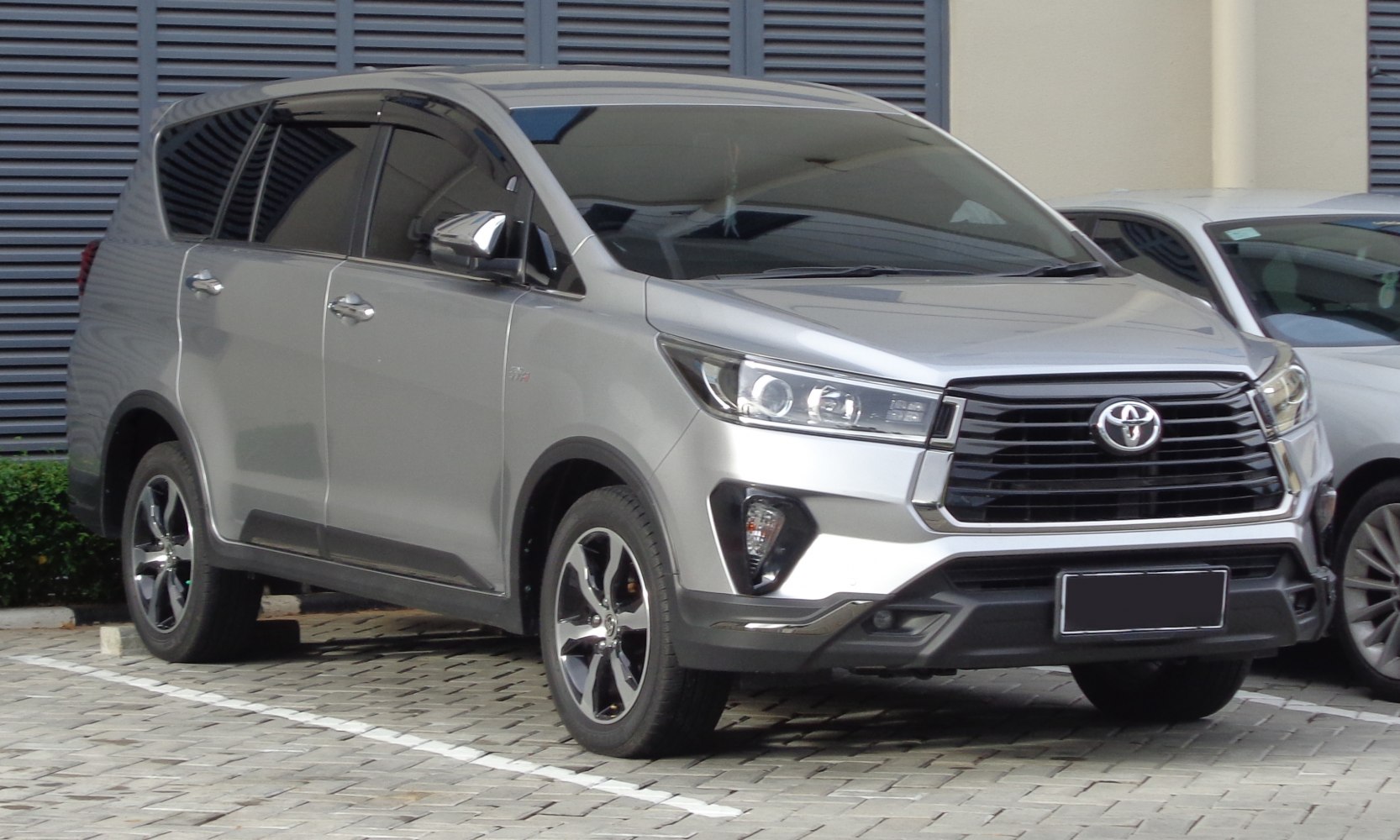 Front side view of a modern MPV with sleek grille and alloy wheels