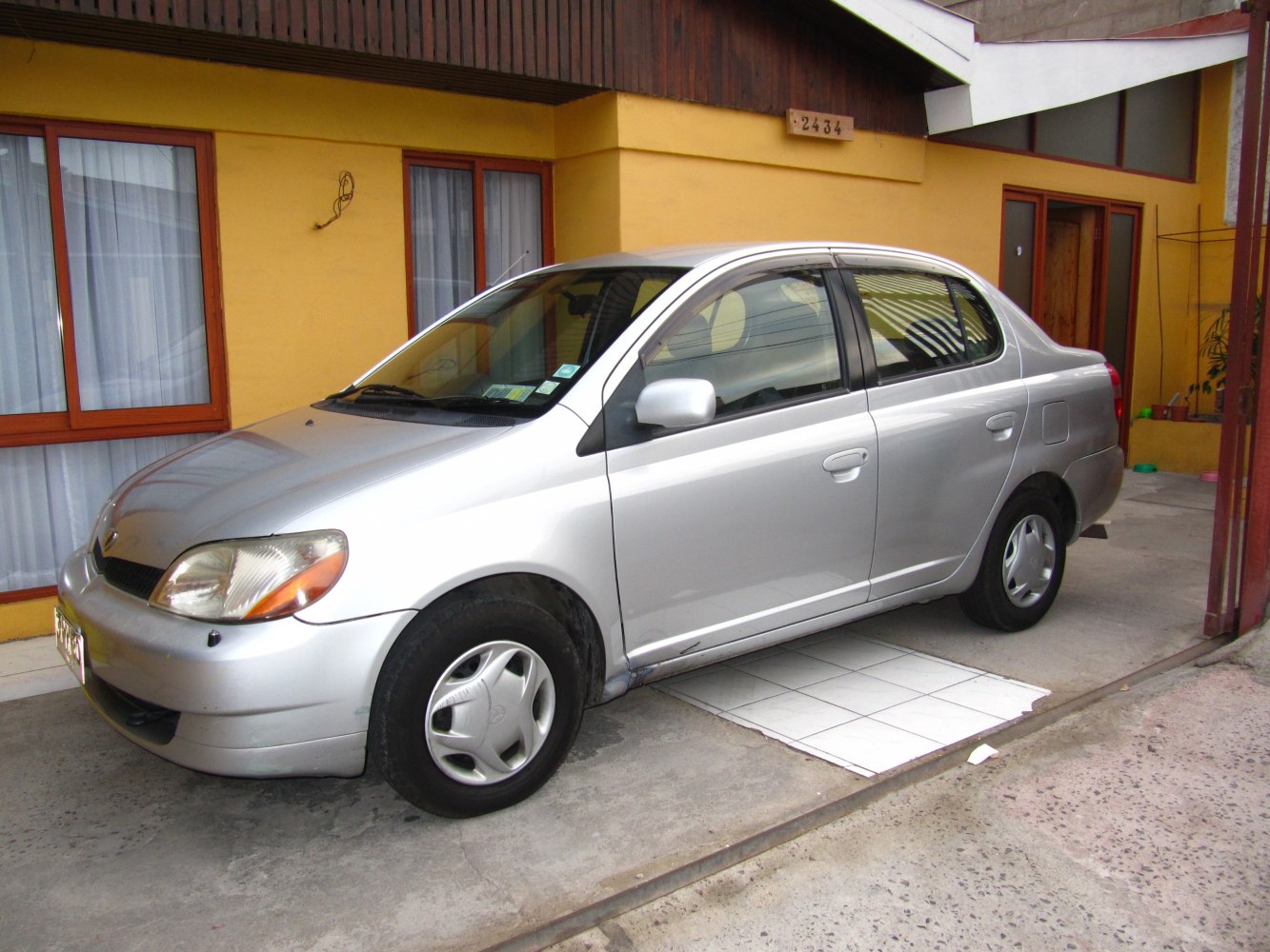Silver compact sedan with hubcaps front side view
